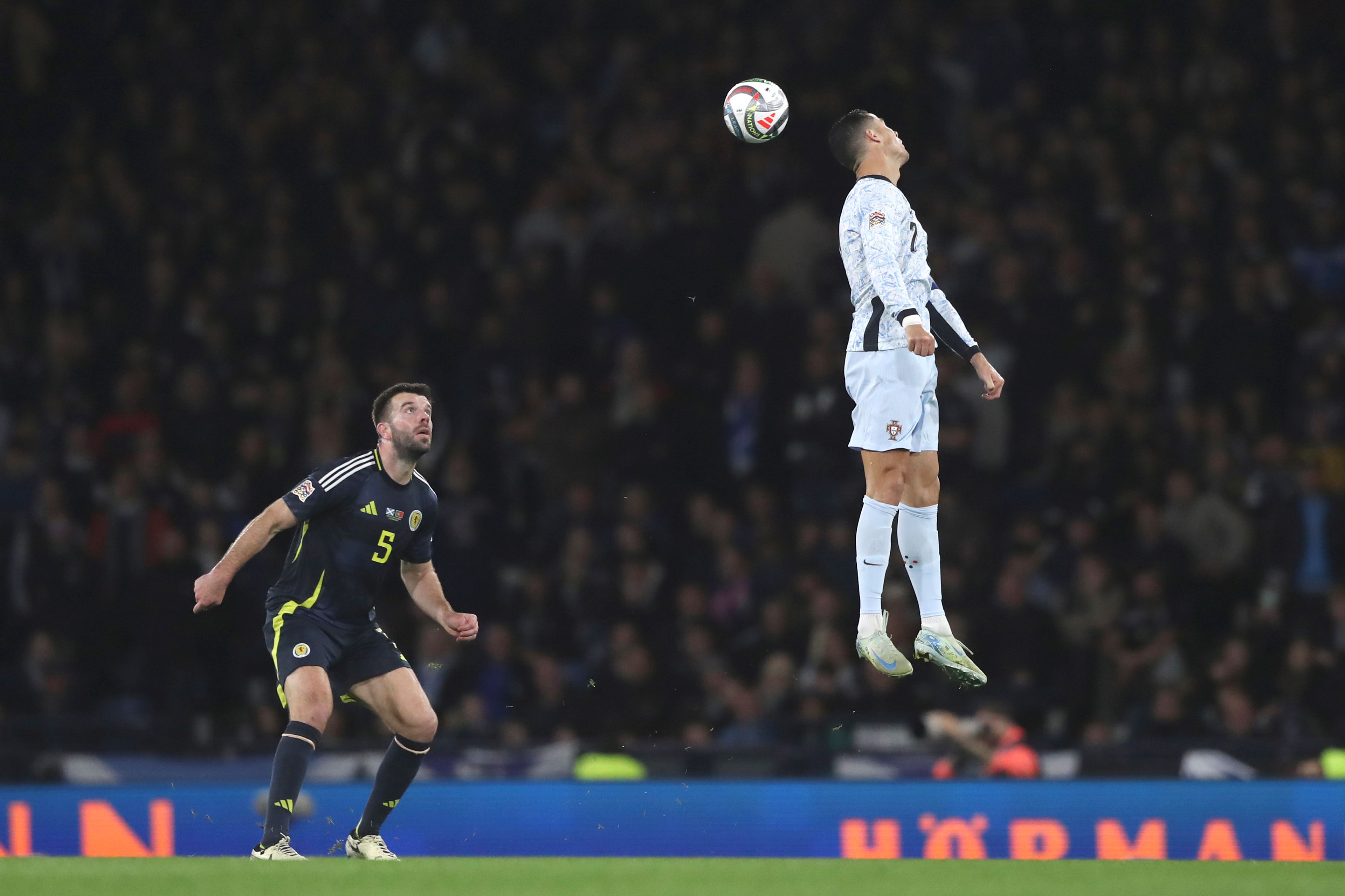 Portugal's Cristiano Ronaldo, right, heads the ball ahead of Scotland's Grant Hanley during the UEFA Nations League soccer match between Scotland and Portugal at Hampden Park in Glasgow, Scotland, Tuesday, Oct. 15, 2024. (AP Photo/Scott Heppell)