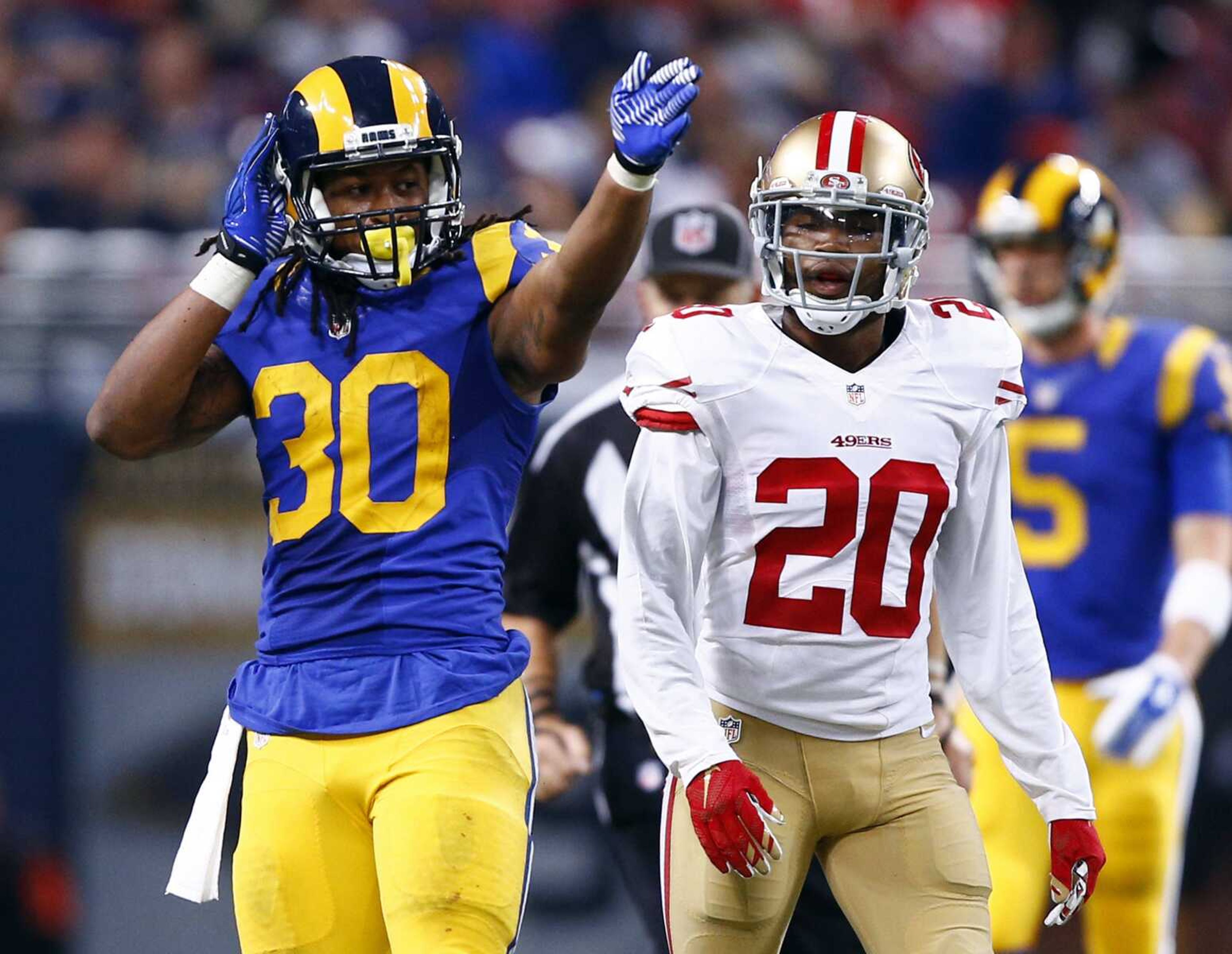 Rams running back Todd Gurley, left, celebrates after running for a first down as San Francisco 49ers cornerback Kenneth Acker looks during the third quarter Sunday in St. Louis. Gurley rushed for 133 yards in the Rams' 27-6 victory. (Billy Hurst ~ Associated Press)