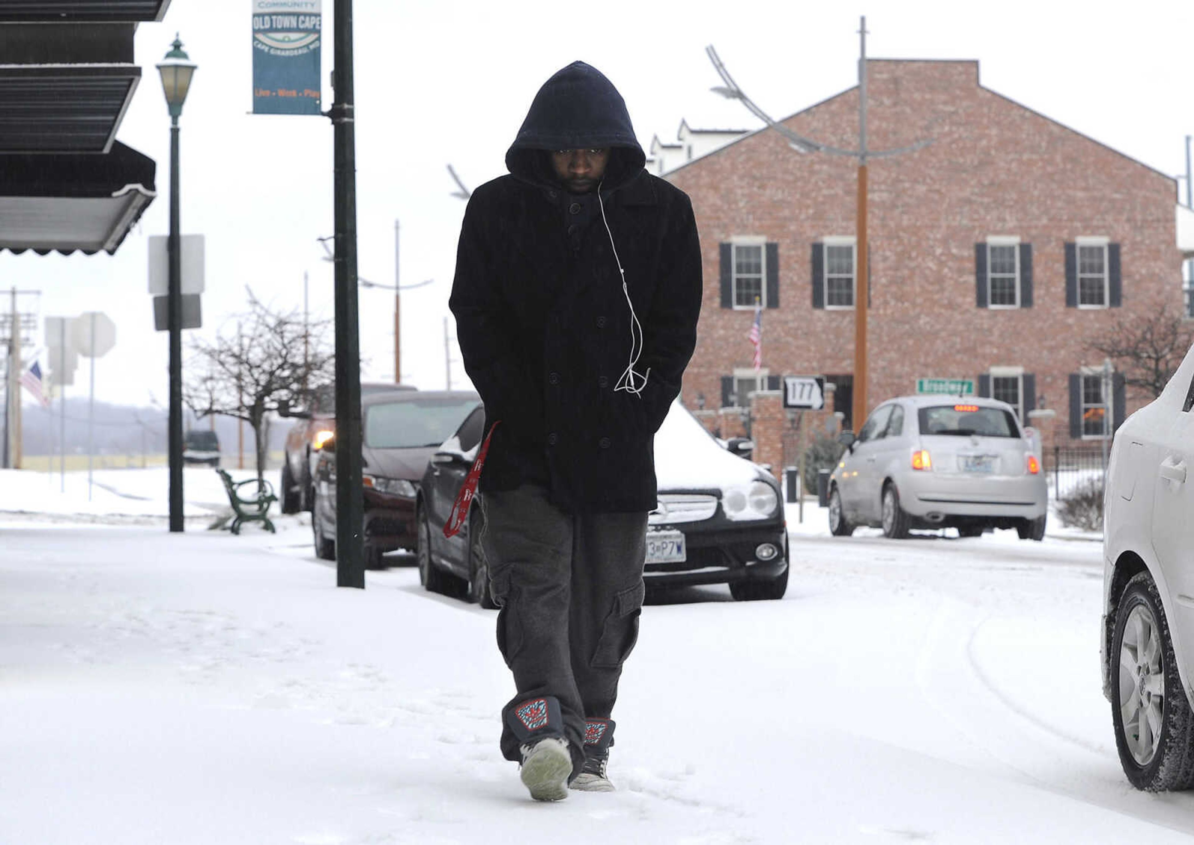 FRED LYNCH ~ flynch@semissourian.com
Darion Pruitt walks along the snow-covered sidewalk on Main Street Sunday morning, Feb. 14, 2016 in downtown Cape Girardeau.