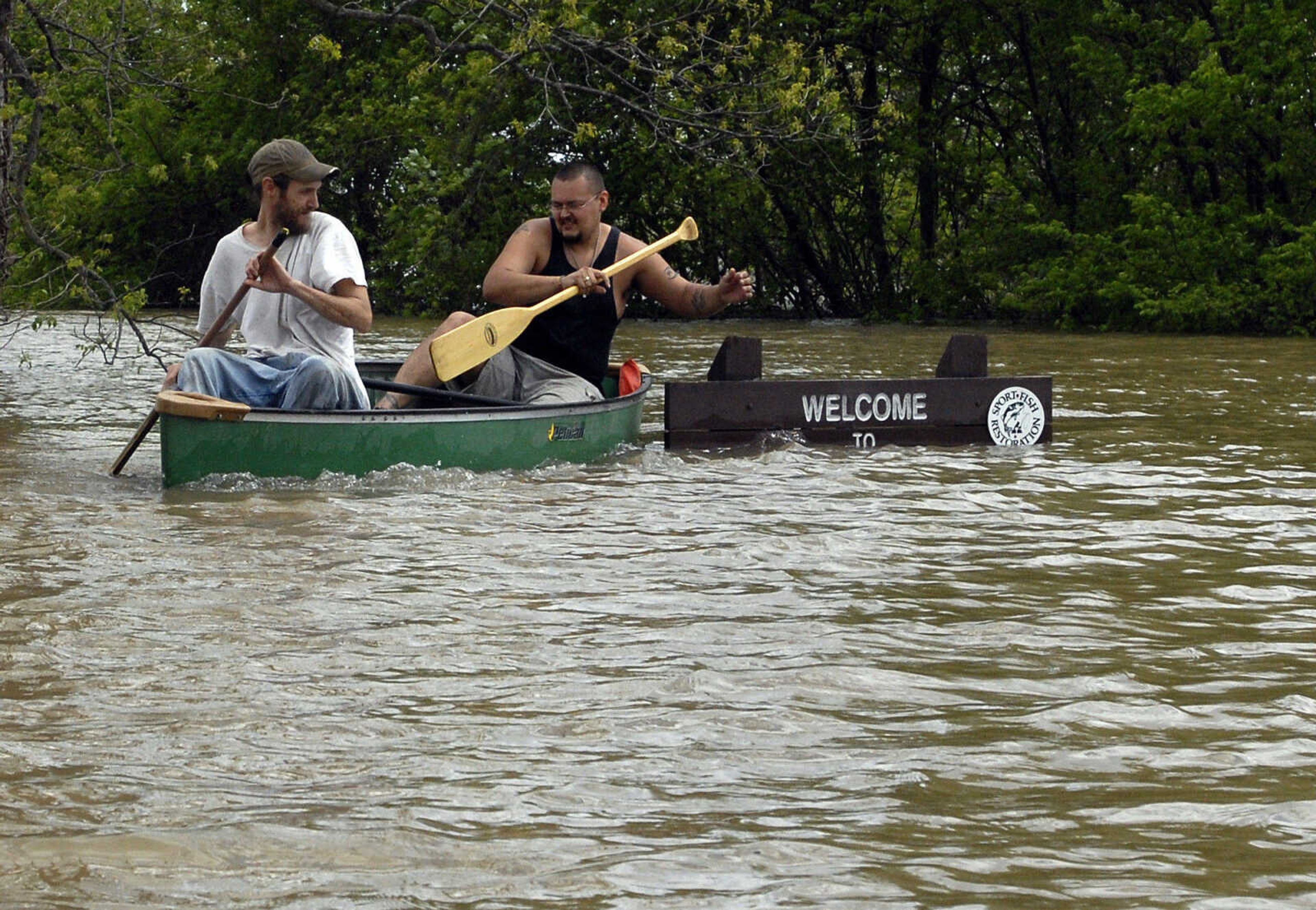 LAURA SIMON~lsimon@semissourian.com
Joshua Robertson, left, and Gabriel Yanes canoe next to a welcome sign as the Mississippi River floods the Red Star district Thursday, April 28, 2011 in Cape Girardeau.