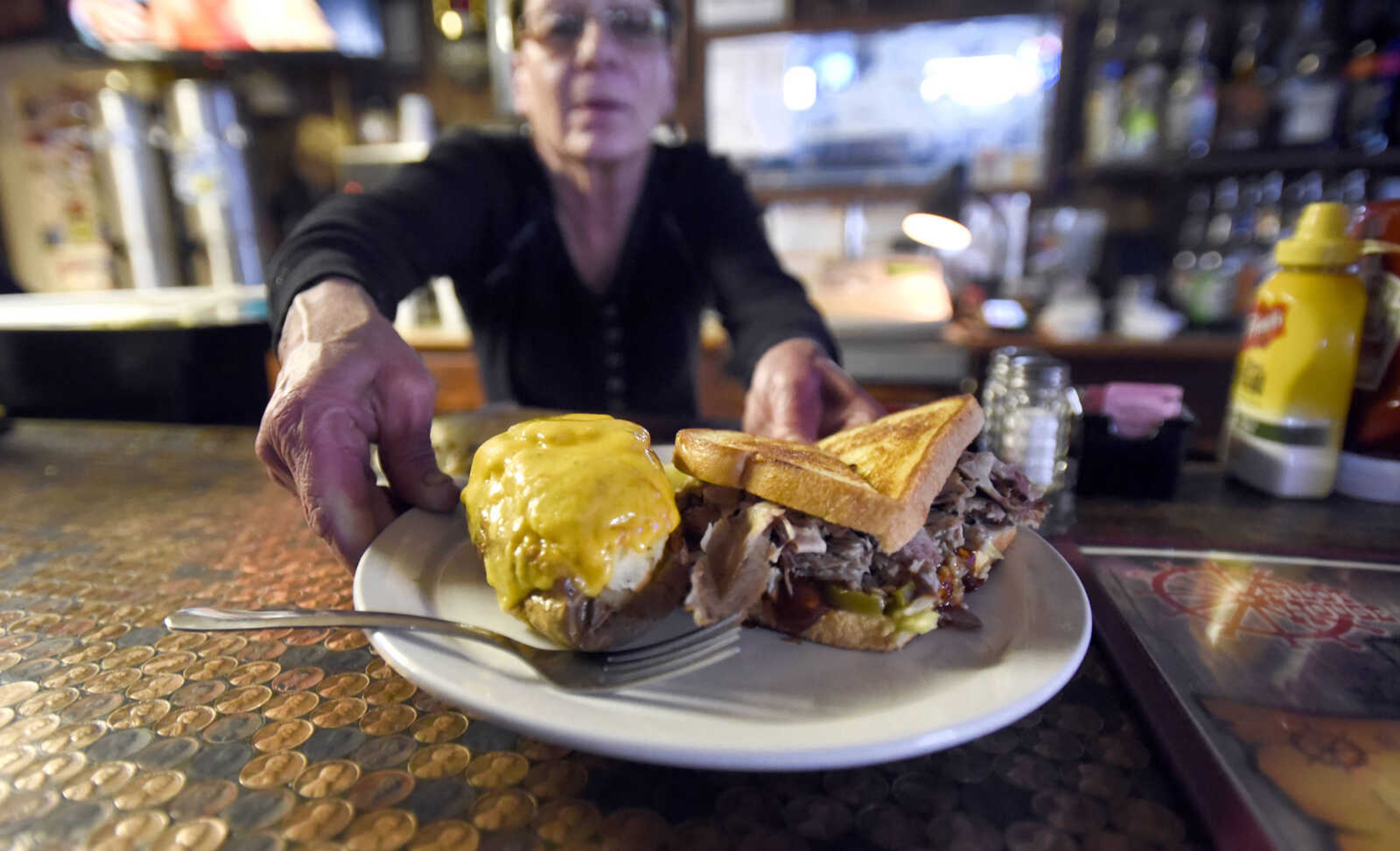 Carletta Bohnert serves a twice-baked potato and a Big Hot Cheese at the Pilot House in Cape Girardeau.