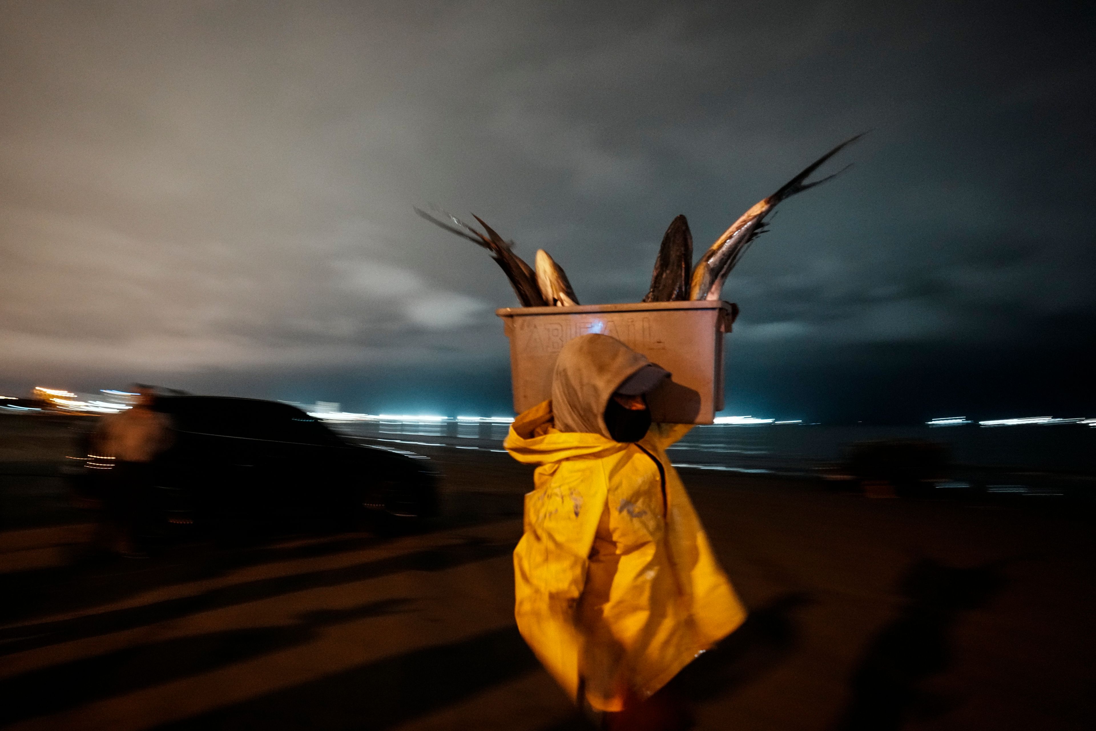 A fisherman carries his catch of the day to market, in Manta, Ecuador, Tuesday, Sept. 24, 2024. (AP Photo/Dolores Ochoa)