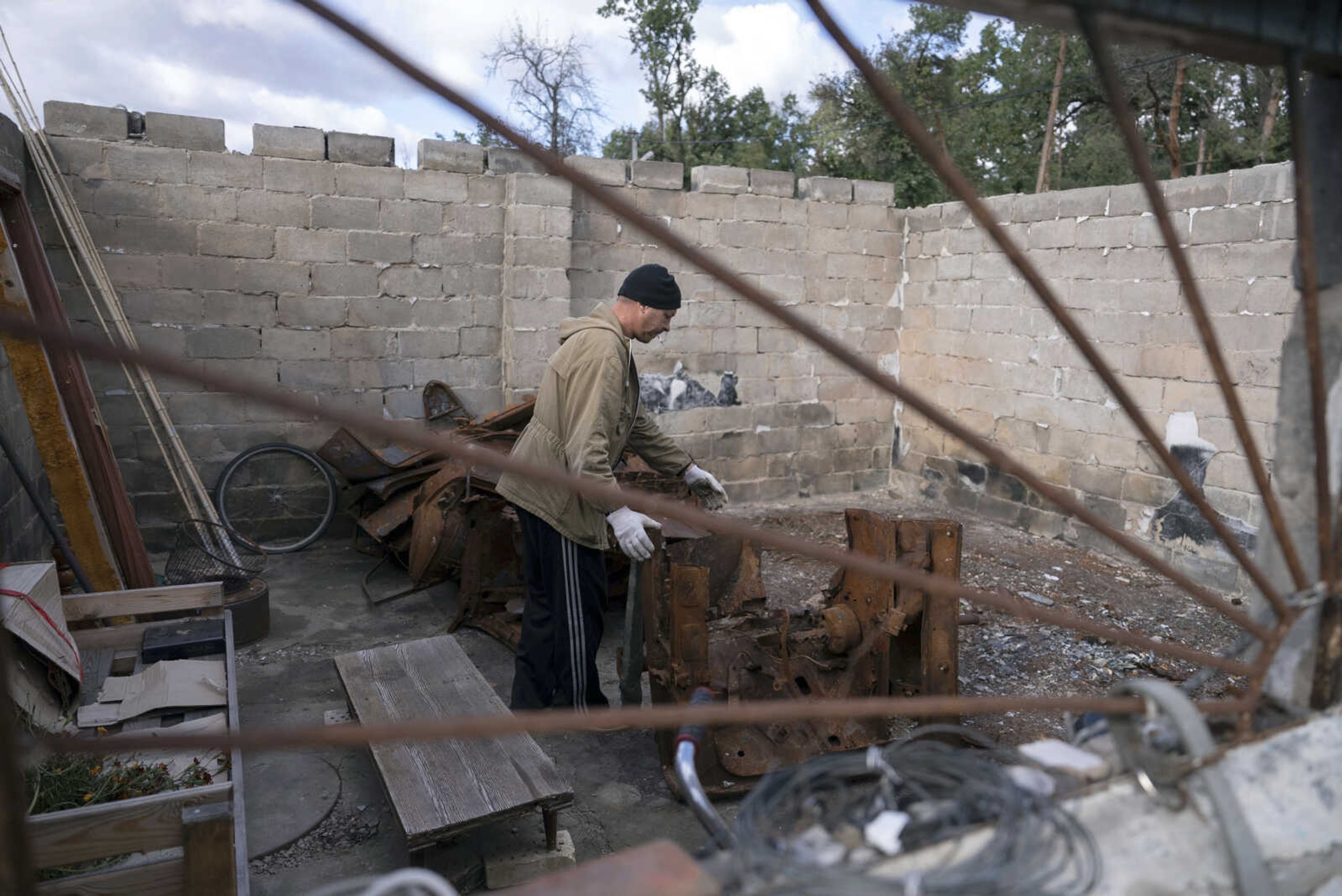 Yuriy Musienko, 45, works in a burned car garage near his mother's house Oct. 10 in Moshchun, near Kyiv, Ukraine. Many Ukrainians are expecting the same or worse this coming winter and have spent months preparing, including collecting firewood and buying generators.