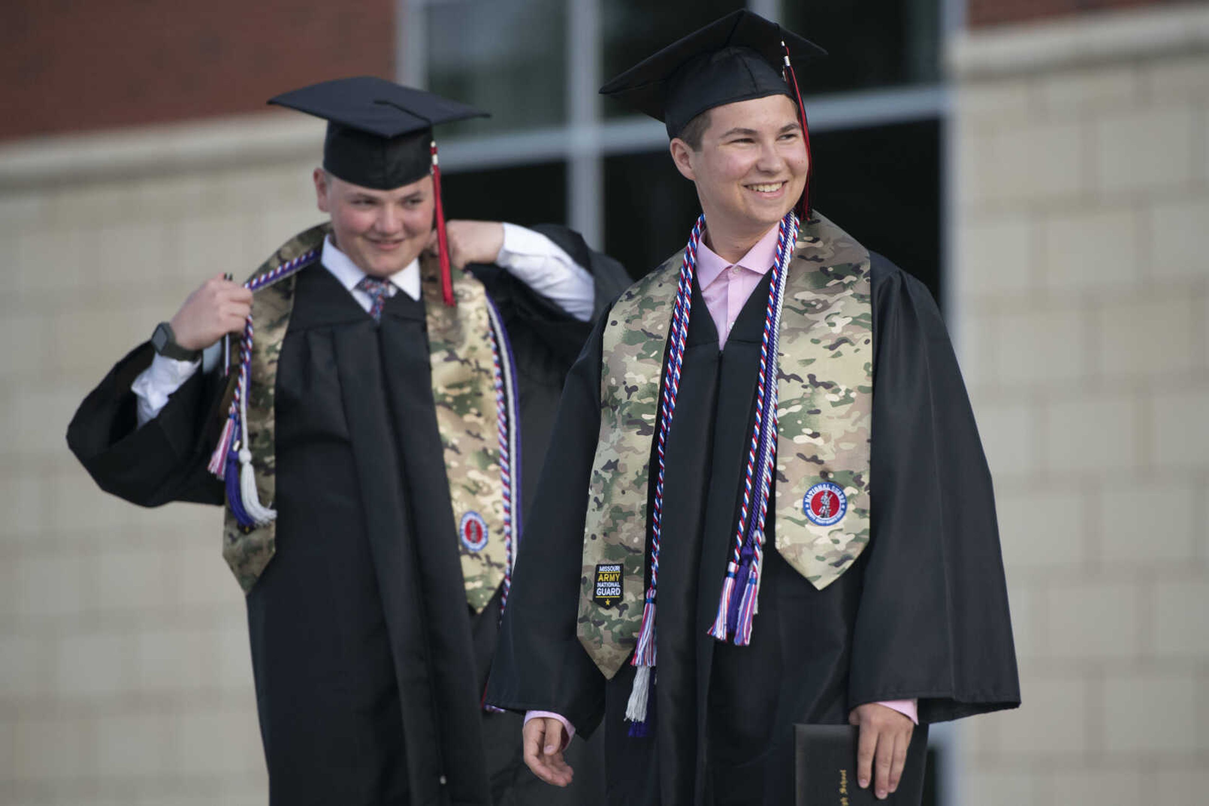 Jackson High School graduates Logan Wayne McClanahan (right) and Caleb Scott Anderson smile during a parade following an in-person military graduation ceremony Friday, May 22, 2020, at Jackson High School.