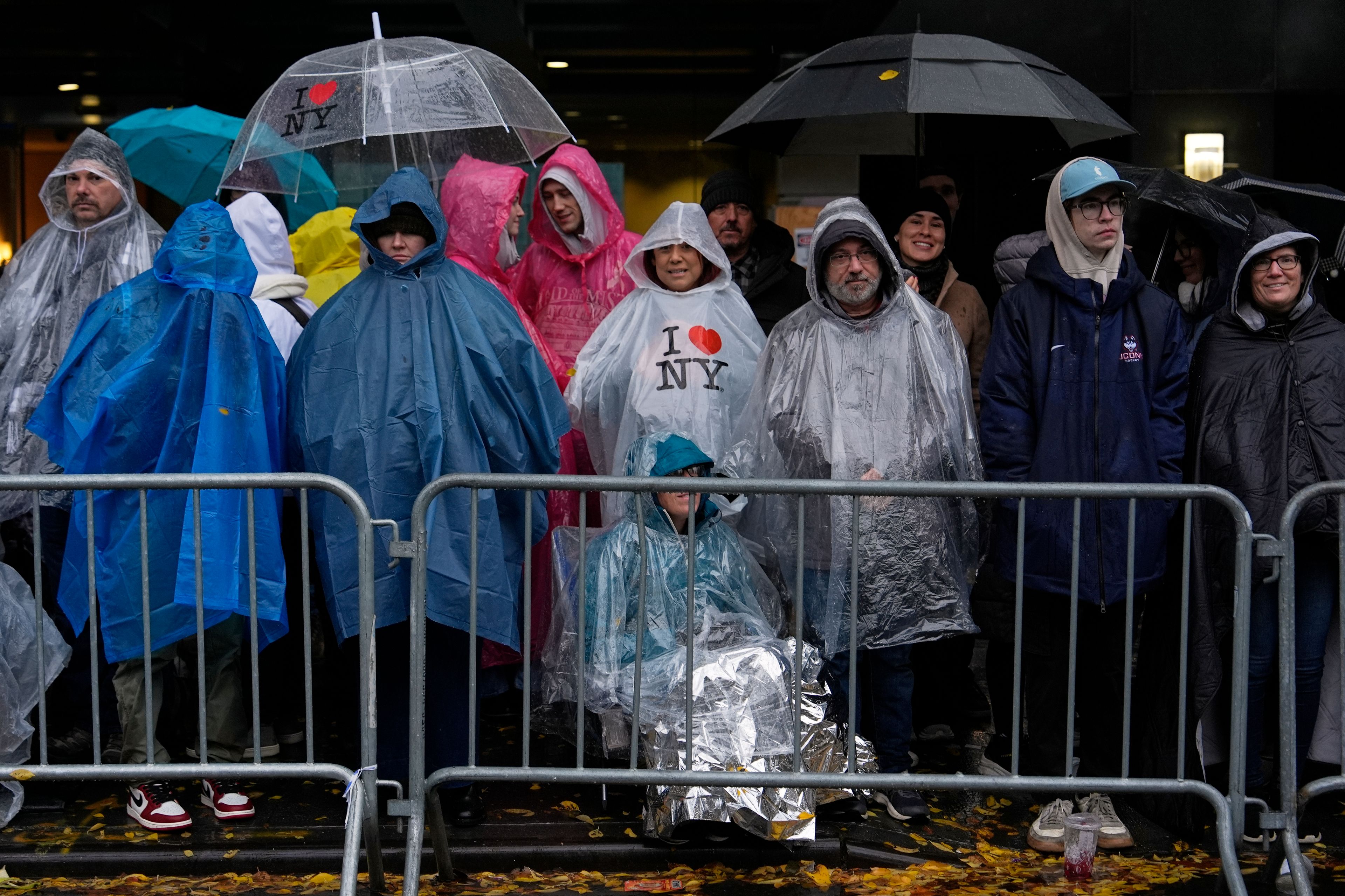 People stand in the rain along Sixth Avenue ahead of the start of the Macy's Thanksgiving Day Parade, Thursday, Nov. 28, 2024, in New York. (AP Photo/Julia Demaree Nikhinson)