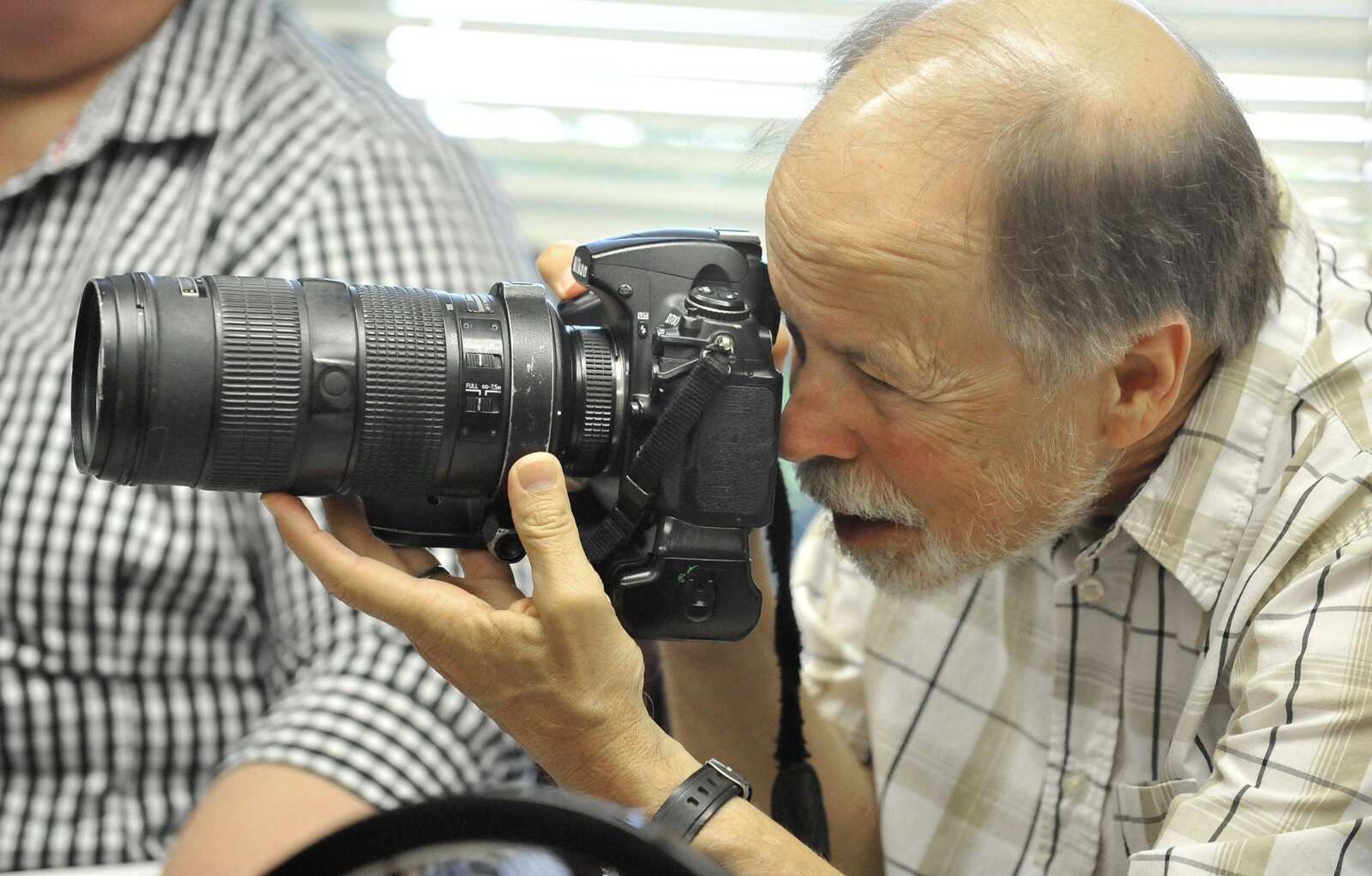 Southeast Missourian photojournalist, Fred Lynch, photographs WWII veteran Howard Thomas on Tuesday, June 6, 2017, at the Cape Girardeau Senior Center.