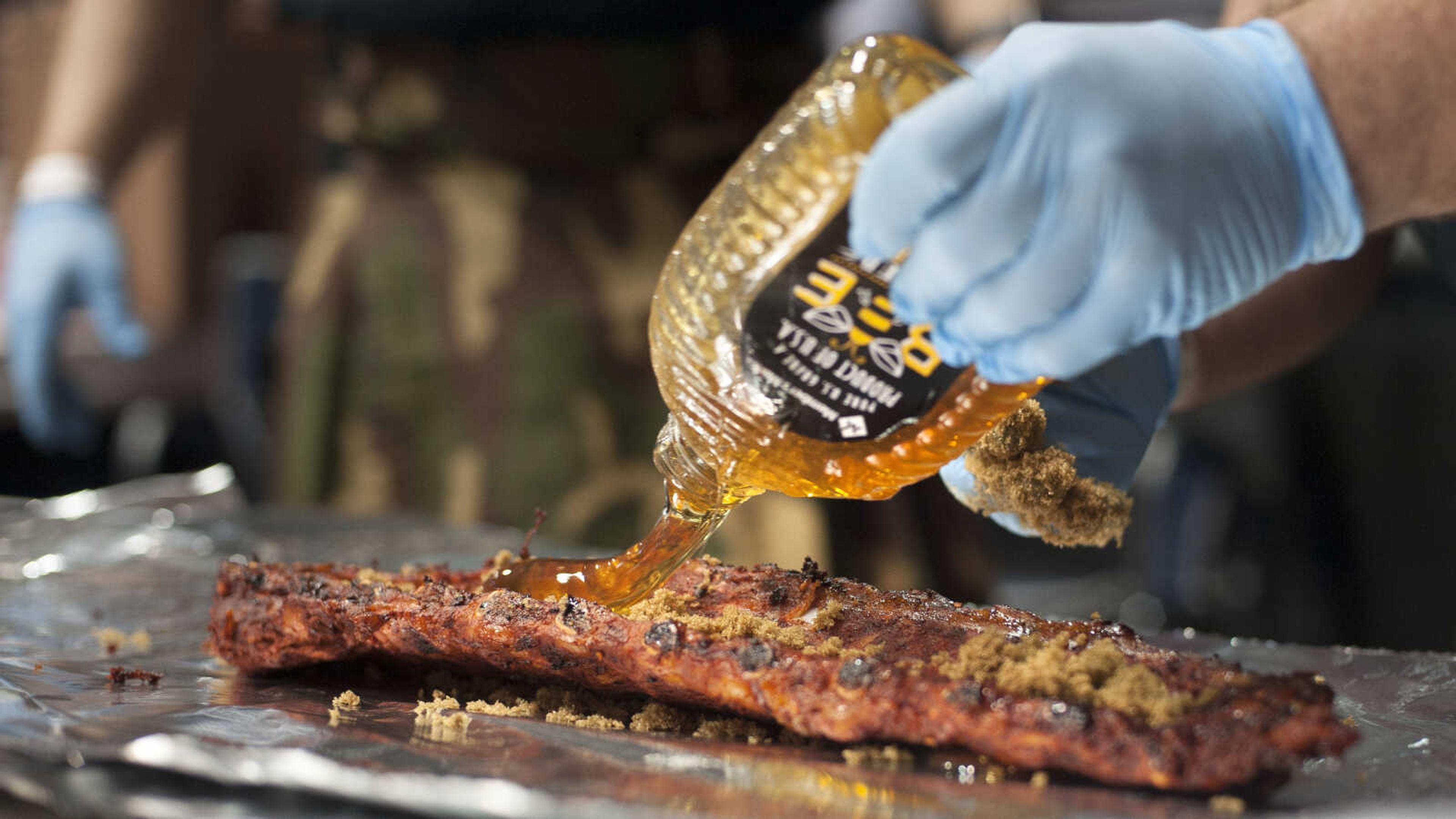 Eric Welter seasons a rack of ribs with, among other ingredients, brown sugar and honey during the "When Pigs Fly" indoor BBQ bash Saturday, Jan. 25, 2020, at the Show Me Center in Cape Girardeau.