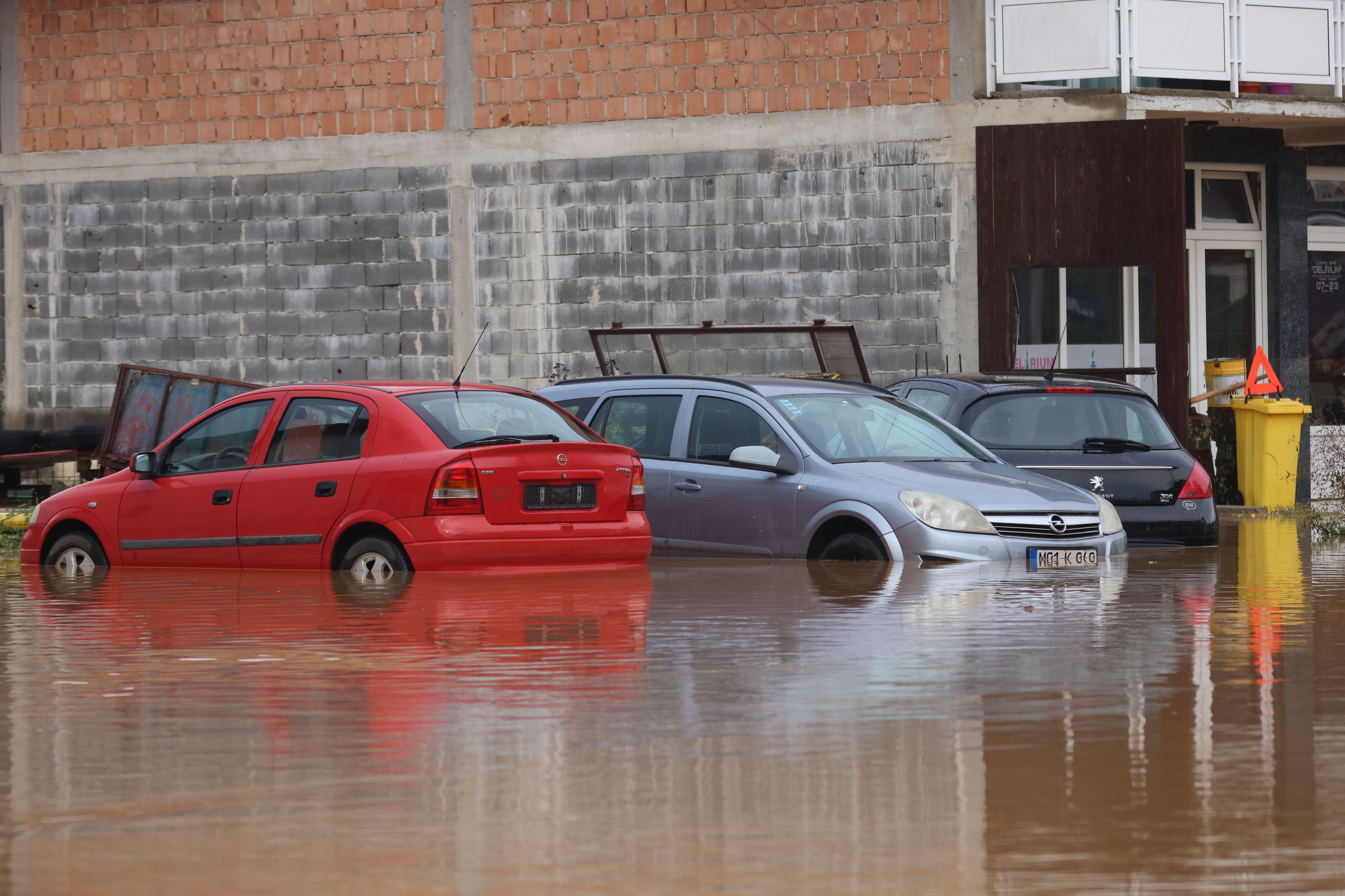 Vehicles are partially submerged in flood waters outside an apartment building in the village of Kiseljak, northern Bosnia, Friday, Oct. 4, 2024. (AP Photo/Armin Durgut)