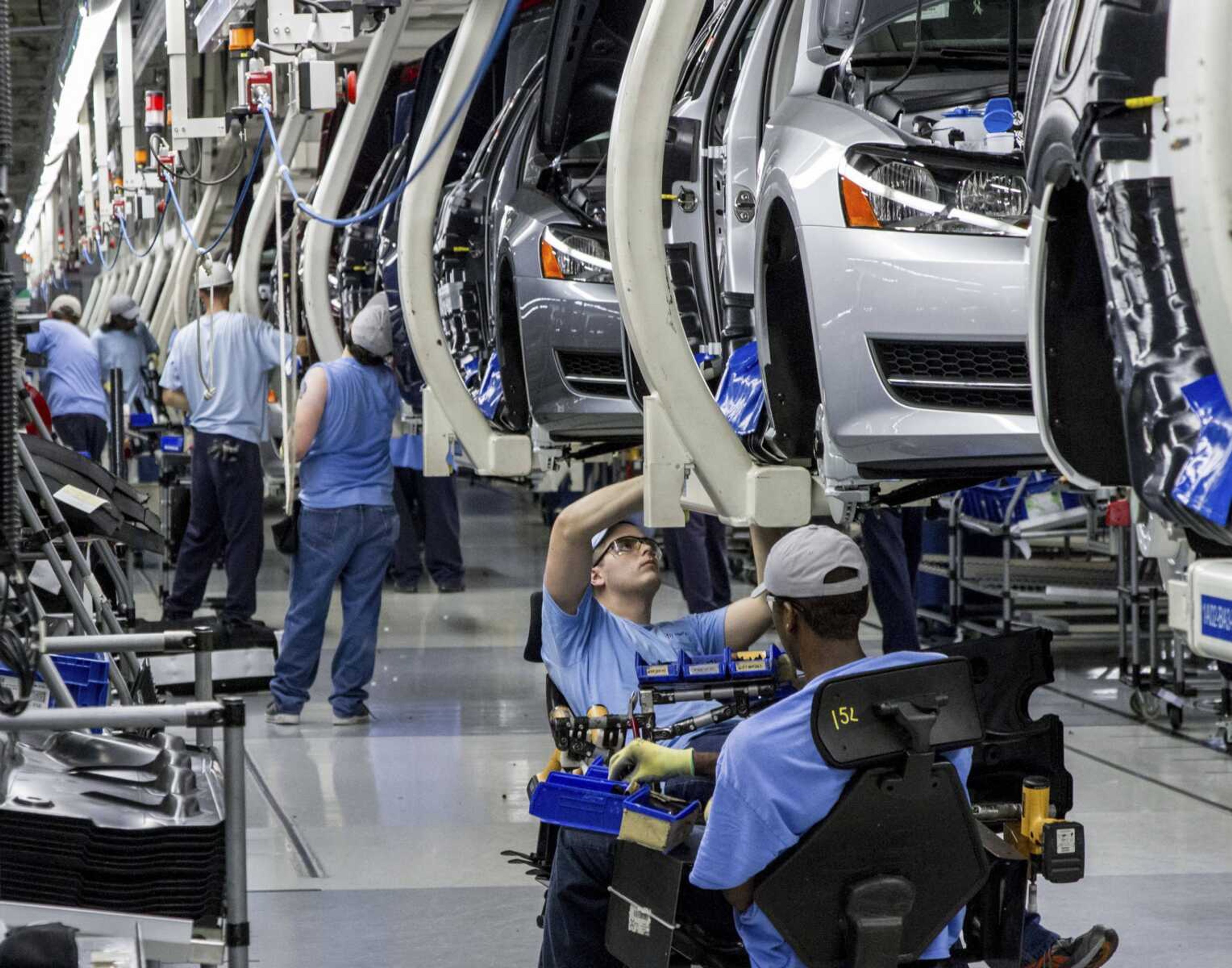 Workers assemble Volkswagen Passat sedans at the German automaker's plant in Chattanooga, Tennessee. Volkswagen will announced a cut in 30,000 jobs during a news conference Friday.