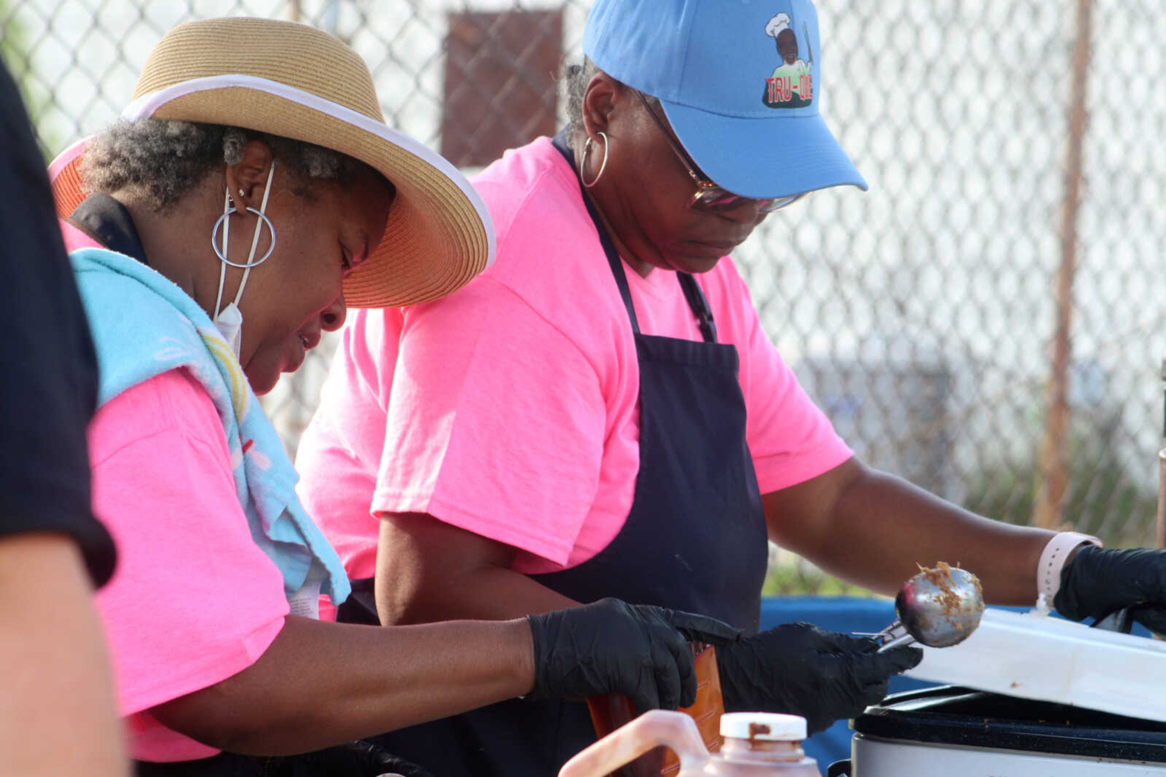 Owner of TruQue in Cape Girardeau Glynis Bonner, left, and Katie Adams serve TruQue barbecue during One City's second annual Juneteenth Celebration on Saturday, June 19, 2021, in the parking lot of One City.