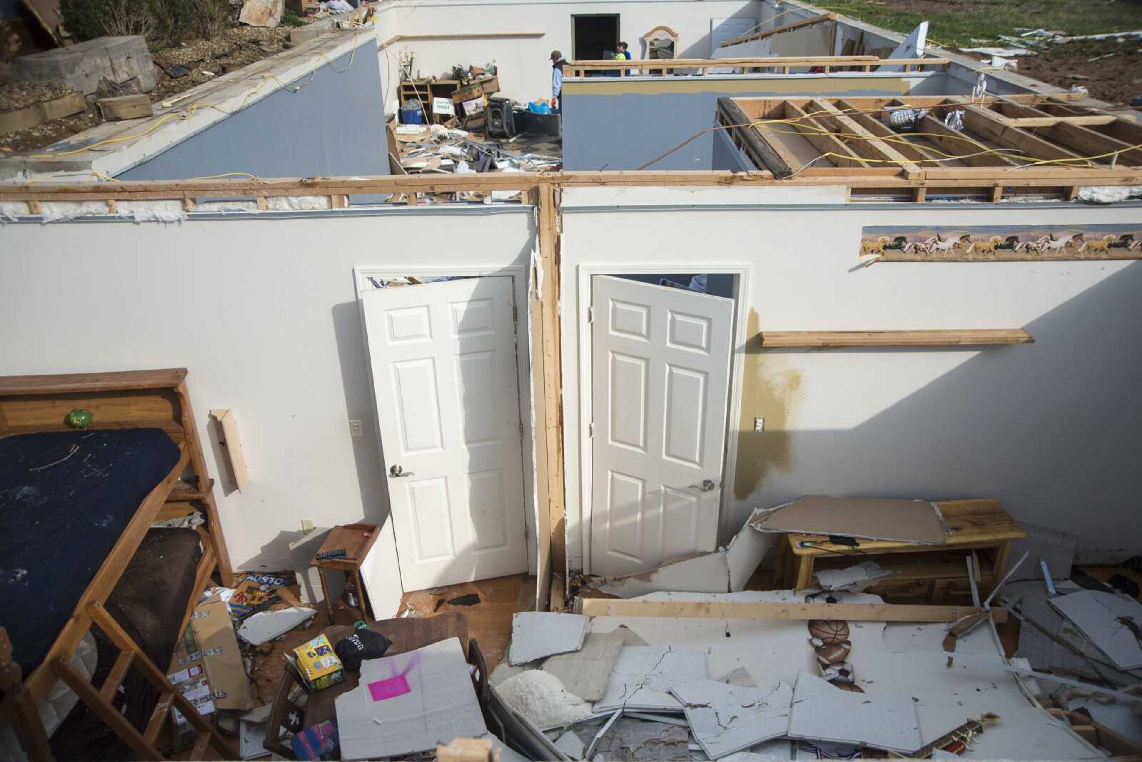 People help cleanup the damage left behind from a tornado along Perry County Road 806 near Kyle Lane on Wednesday, March 1, 2017, in Perry County.