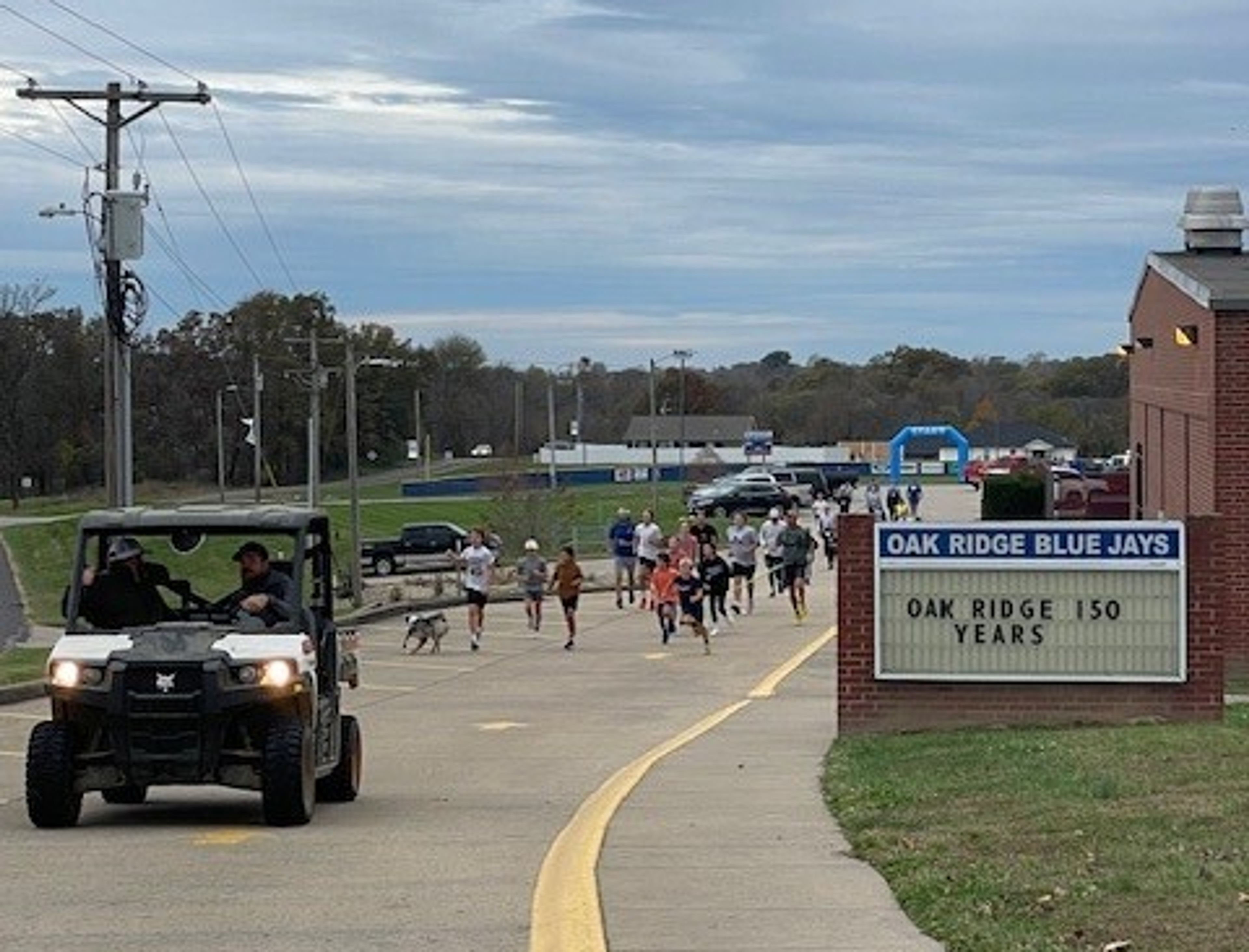 Participants in the Oak Ridge Sesquicentennial 5K run past Oak Ridge High School on Saturday, Nov. 9.