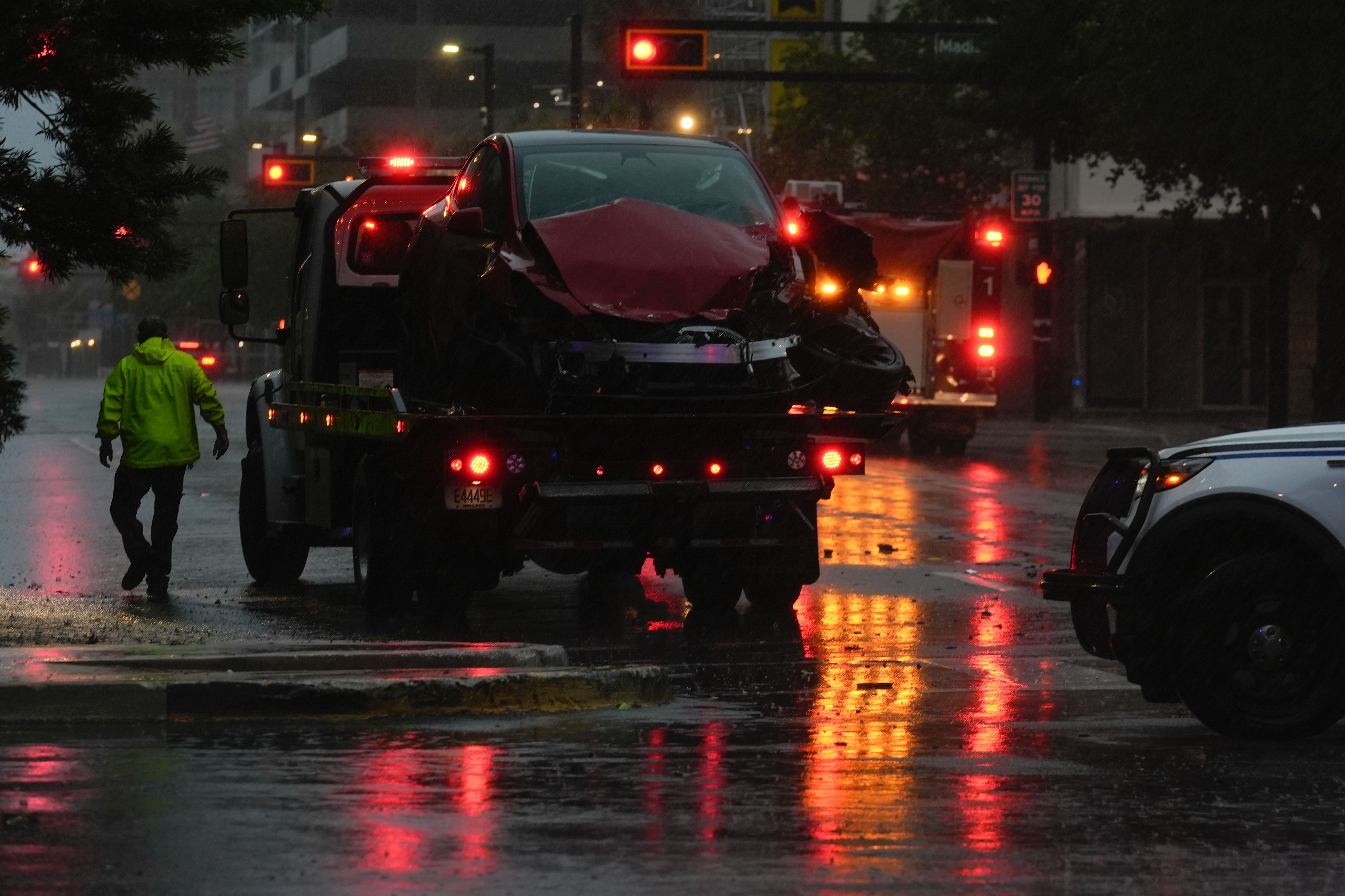 A tow truck responds following a traffic accident between a car and a fire truck returning from a call, on near-deserted streets in downtown Tampa, Fla., during the approach of Hurricane Milton, Wednesday, Oct. 9, 2024. (AP Photo/Rebecca Blackwell)