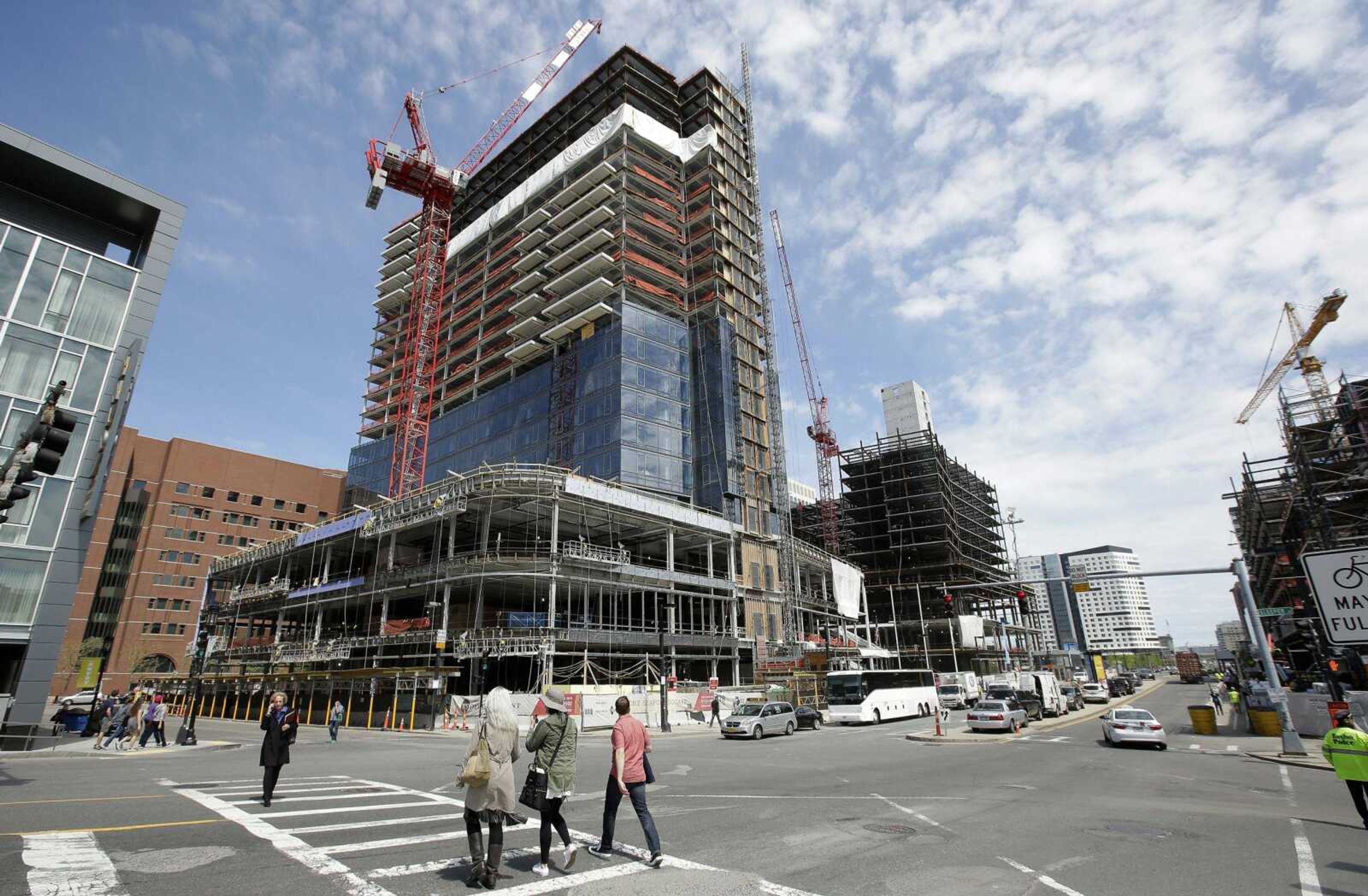 Passers-by walk near the construction site of a high-rise building in Boston.