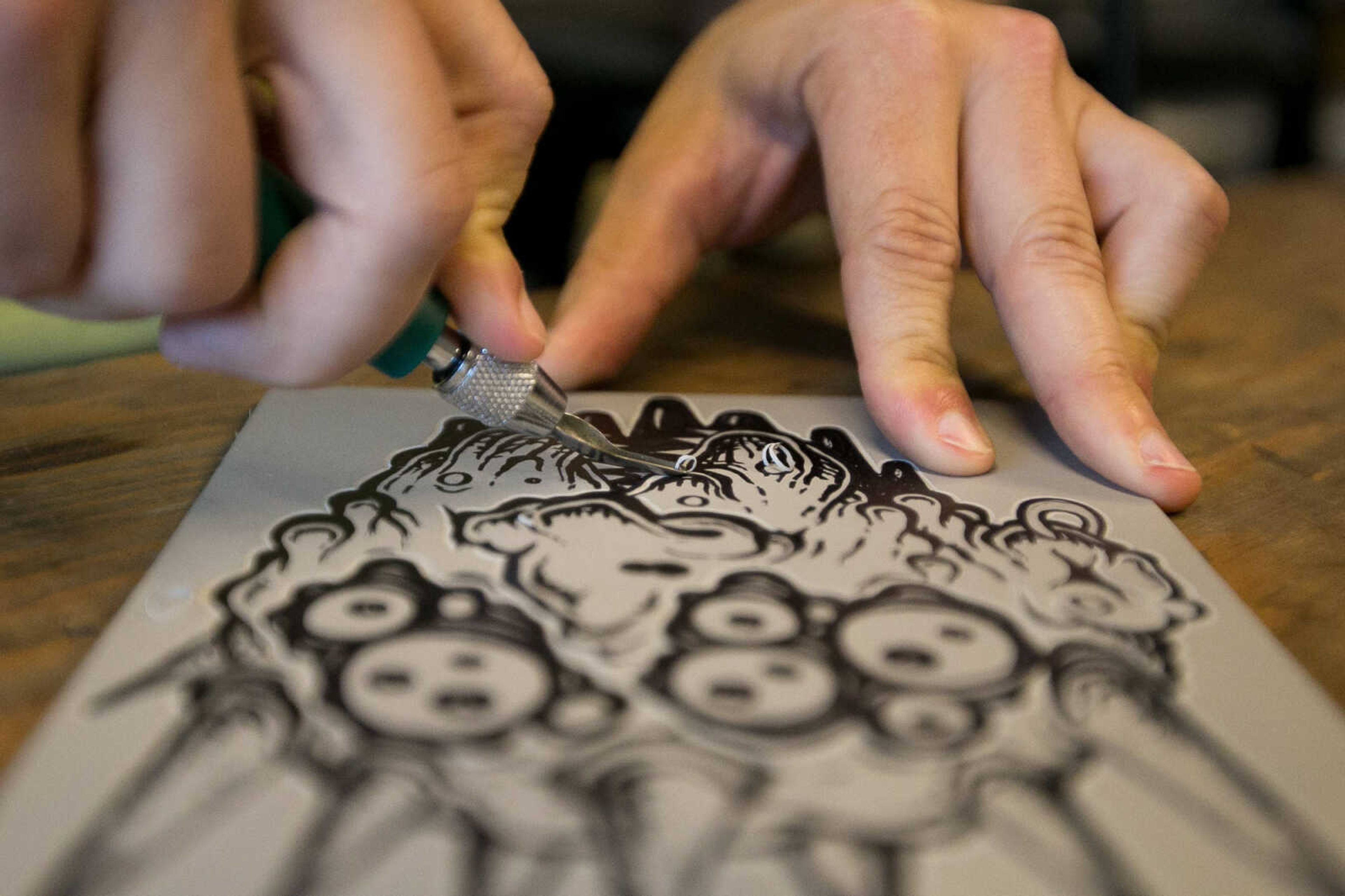 GLENN LANDBERG ~ glandberg@semissourian.com

Justin Miller, a professor at Southeast Missouri State University, demonstrates the carving of a linocut Saturday, June 18, 2016 at the River Campus Summer Arts Festival.