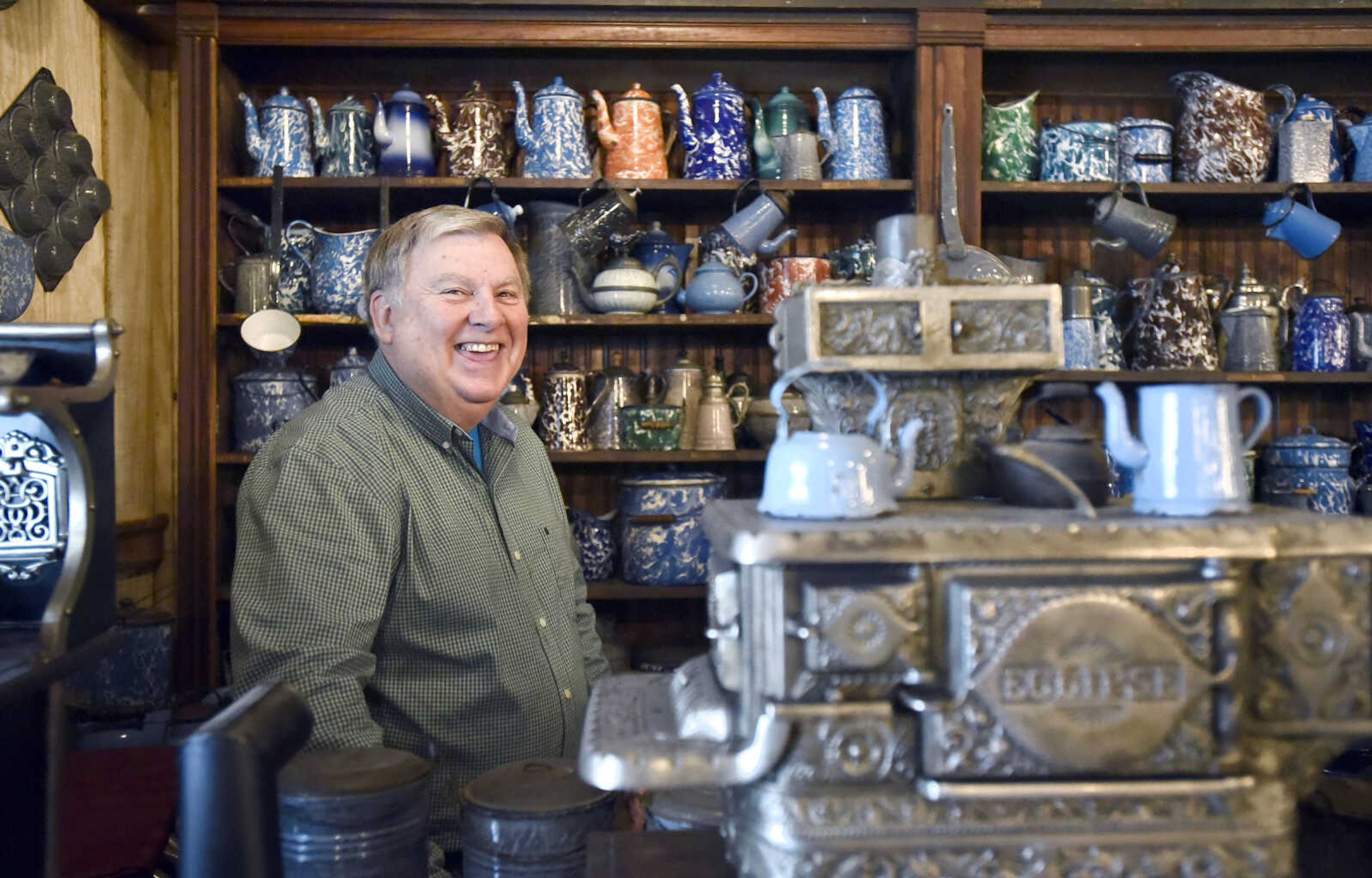 Harlan Smothers sits among his collection of small stoves and graniteware inside his Fat Chance General Store in Cape Girardeau County.