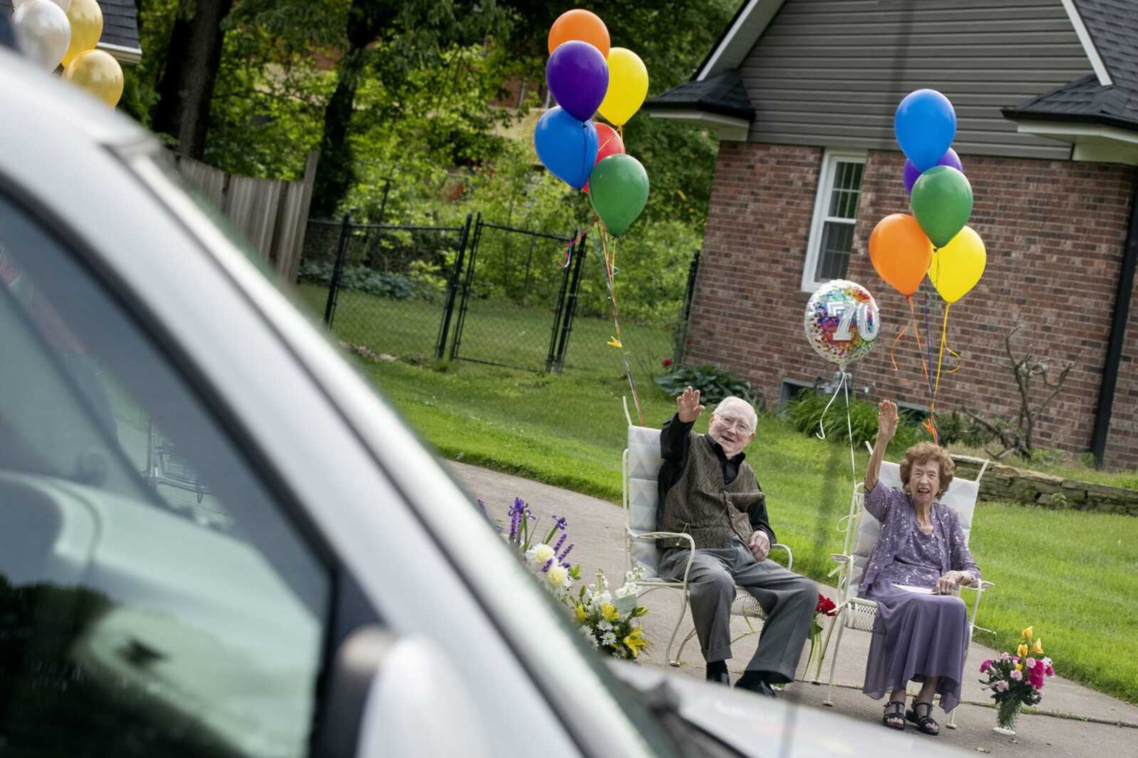 On their 70th wedding anniversary, Kenneth and Martha Bender wave during a parade held in their honor Friday, May 15, 2020, in the driveway of their Cape Girardeau home. Neighbor Joe McLemore had the idea for the parade and said, on the phone before the event, the Benders were to be presented with proclamations from the state and city before the procession.