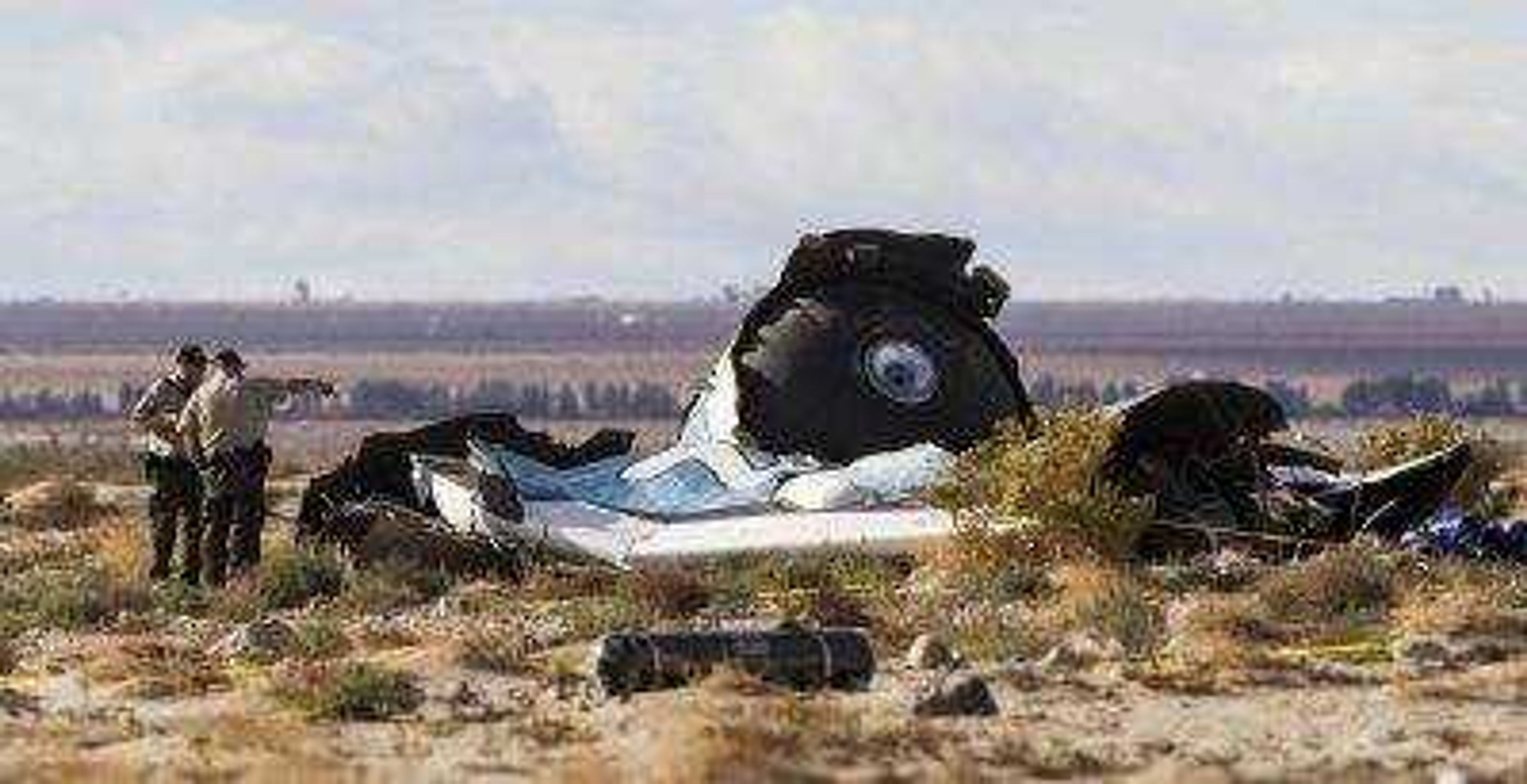 Law enforcement officers take a closer look at wreckage near the site where a Virgin Galactic space tourism rocket, SpaceShipTwo, exploded and crashed Friday in Mojave, California.