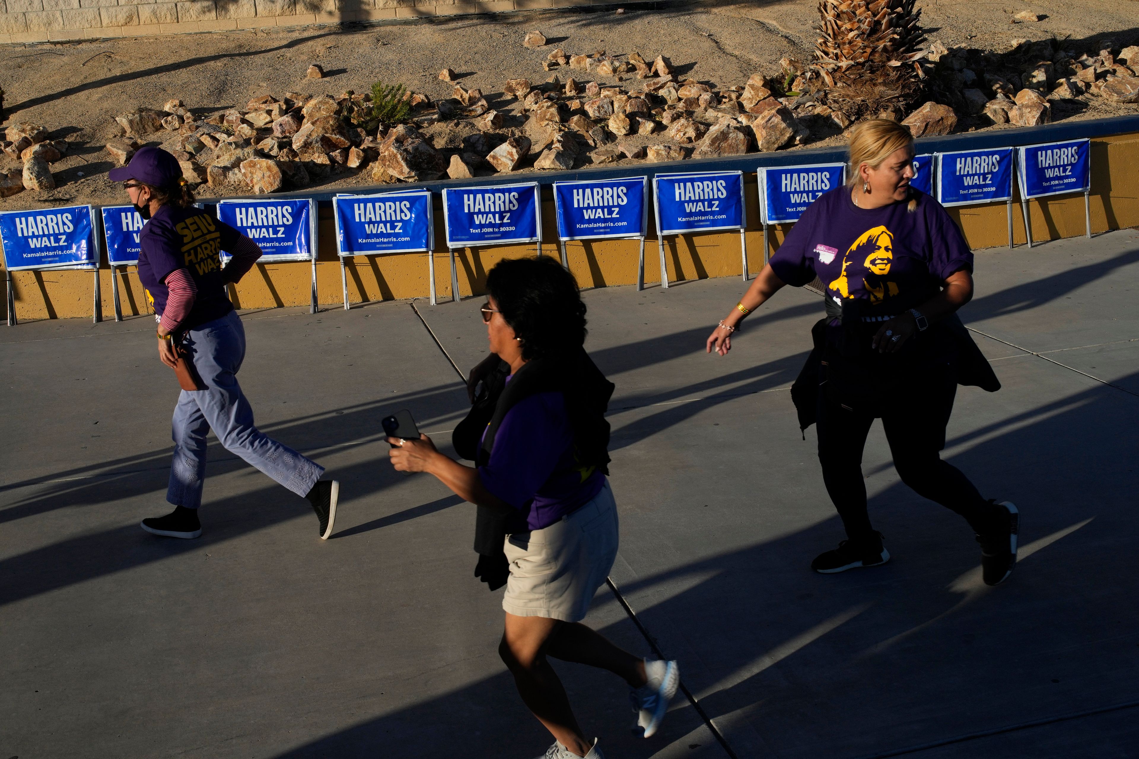 People rush to to attend a rally with former President Barack Obama speaking in support of Democratic presidential nominee Vice President Kamala Harris, Saturday, Oct. 19, 2024, in North Las Vegas, Nev. (AP Photo/John Locher)