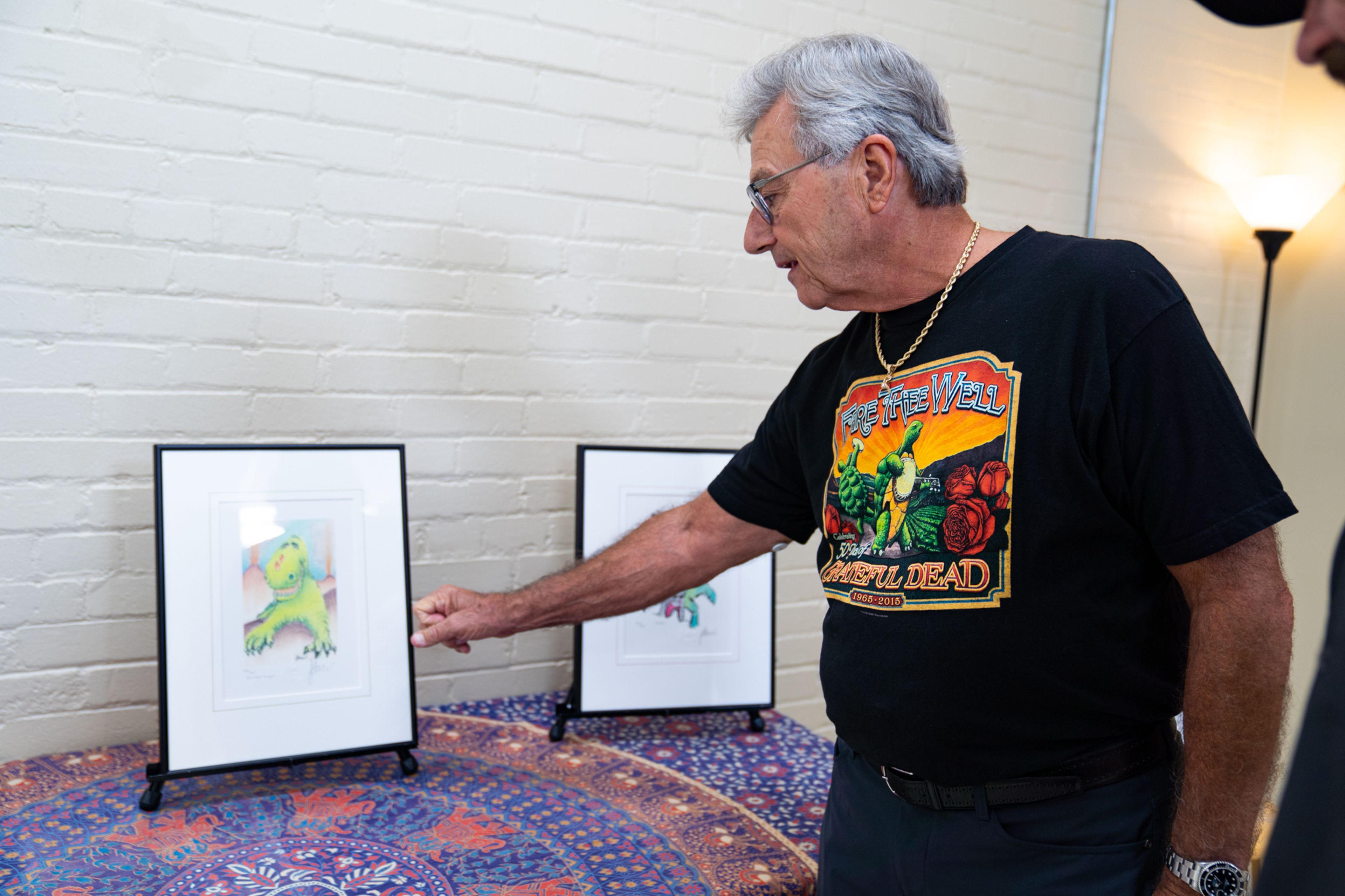 Keith Holloway showed a piece of art from the Jerry Garcia exhibit to an onlooker on Friday, Sept. 20 at Yoga East Healing Arts Studio. Holloway showed his collection of Jerry Garcia art to raise funds for the Jack Finney Foundation.