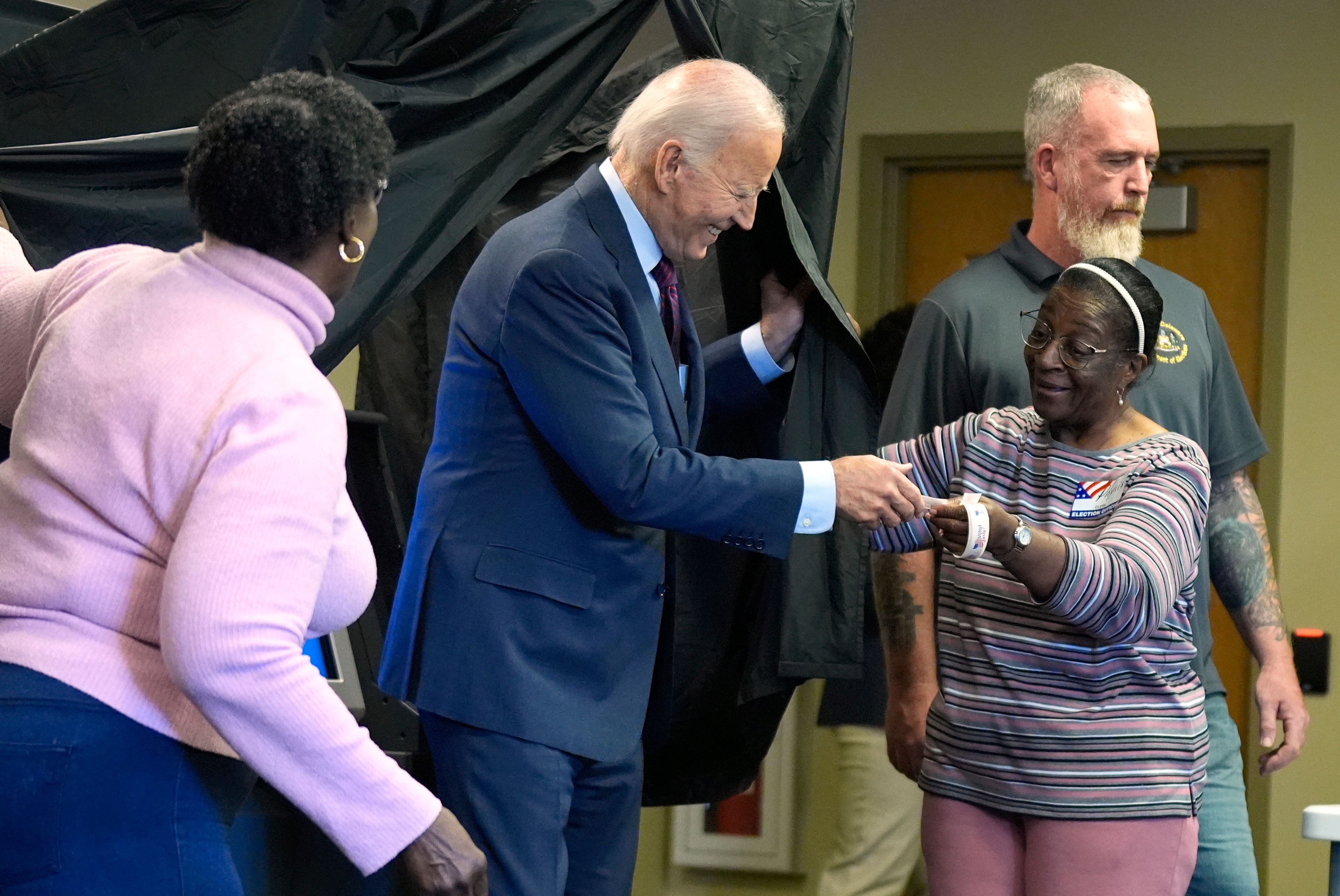 President Joe Biden is handed an "I Voted Early" sticker upon exiting the voting booth after casting his early-voting ballot for the 2024 general elections, Monday, Oct. 28, 2024, in New Castle, Del. (AP Photo/Manuel Balce Ceneta)