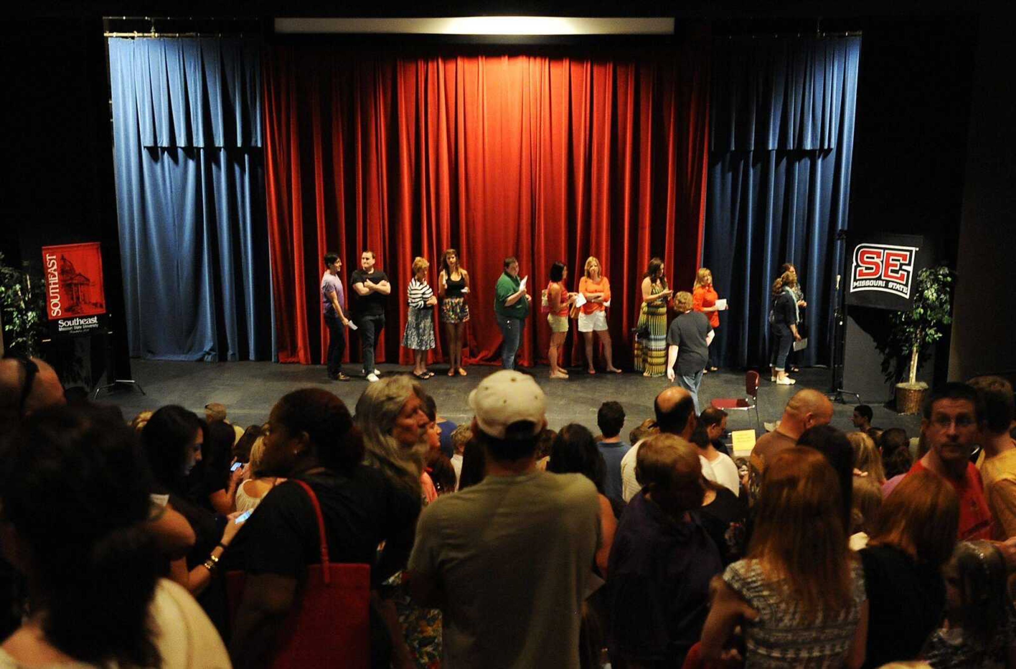 Prospective actors wait in line to have their photo taken during a casting call for the feature film "Gone Girl," Saturday, Aug. 17, at the Rose Theater on the Southeast Missouri State University campus. Hundreds of local residents attended the open casting call in hopes of a chance to be an background extras in the film. (Adam Vogler)