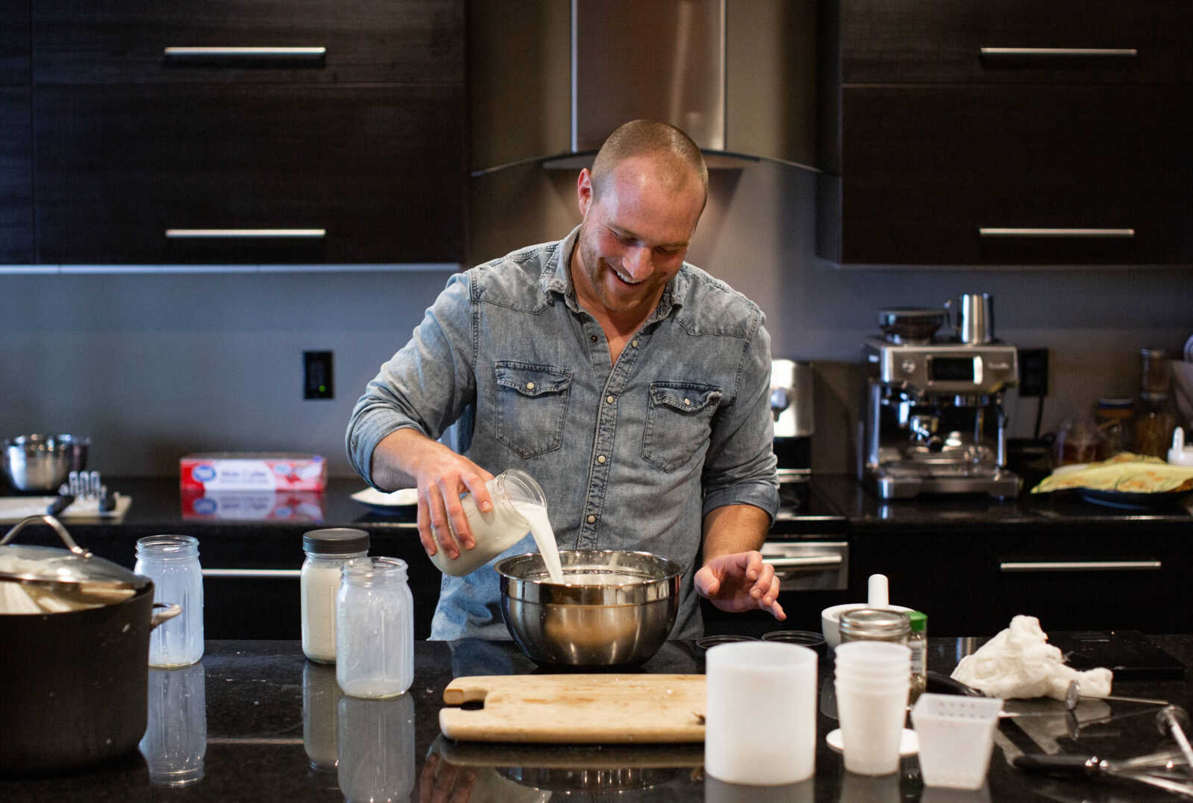 Trever Duncan pours fresh goat milk into a bowl as he prepares to make cheese. To begin making cheese, the milk must cool from 103 degrees to 86 degrees.