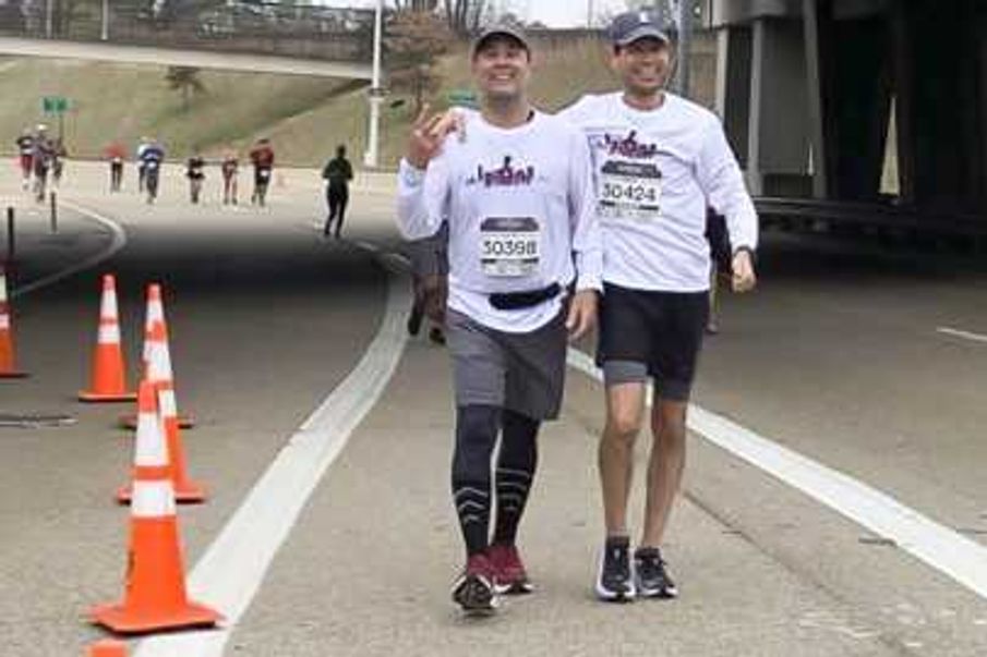 Scott Kruse, left, runs alongside his lifelong friend David Robinson during the St. Jude Memphis Marathon on Saturday in Memphis, Tennessee.