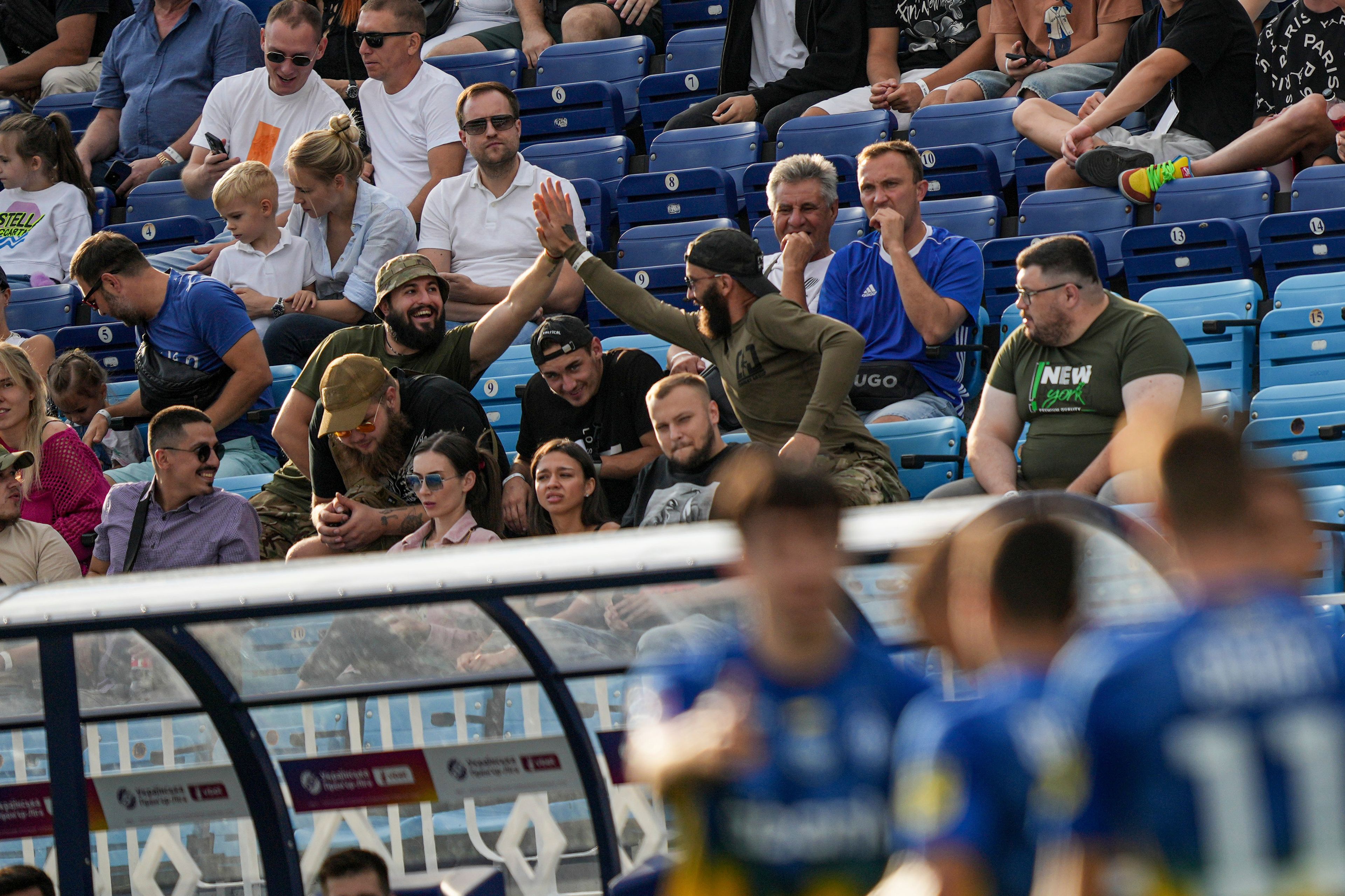 Ukrainian serviceman of Azov Brigade, also known by the call sign "Escobar", center left, celebrates a goal of Dynamo Kyiv during a soccer match with Zorya Luhansk in Kyiv, Ukraine, Saturday Sept. 14, 2024. (AP Photo/Evgeniy Maloletka)