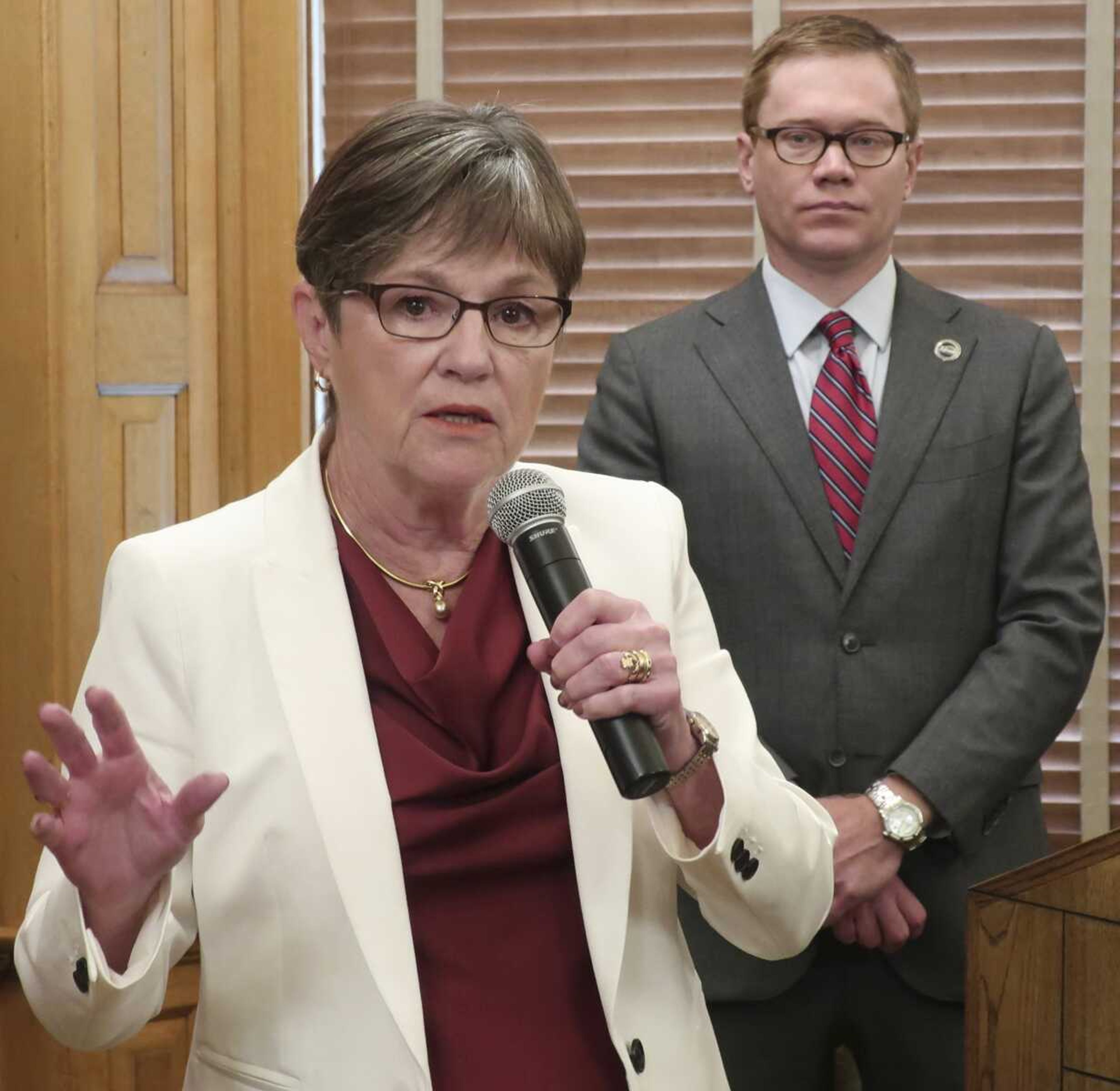 Kansas Gov. Laura Kelly answers questions from reporters Friday after signing her executive order aimed at ending an economic "border war" between Kansas and Missouri over jobs in the Kansas City area at the Statehouse in Topeka, Kansas.<br>Standing behind her is Kansas Commerce Secretary David Toland.