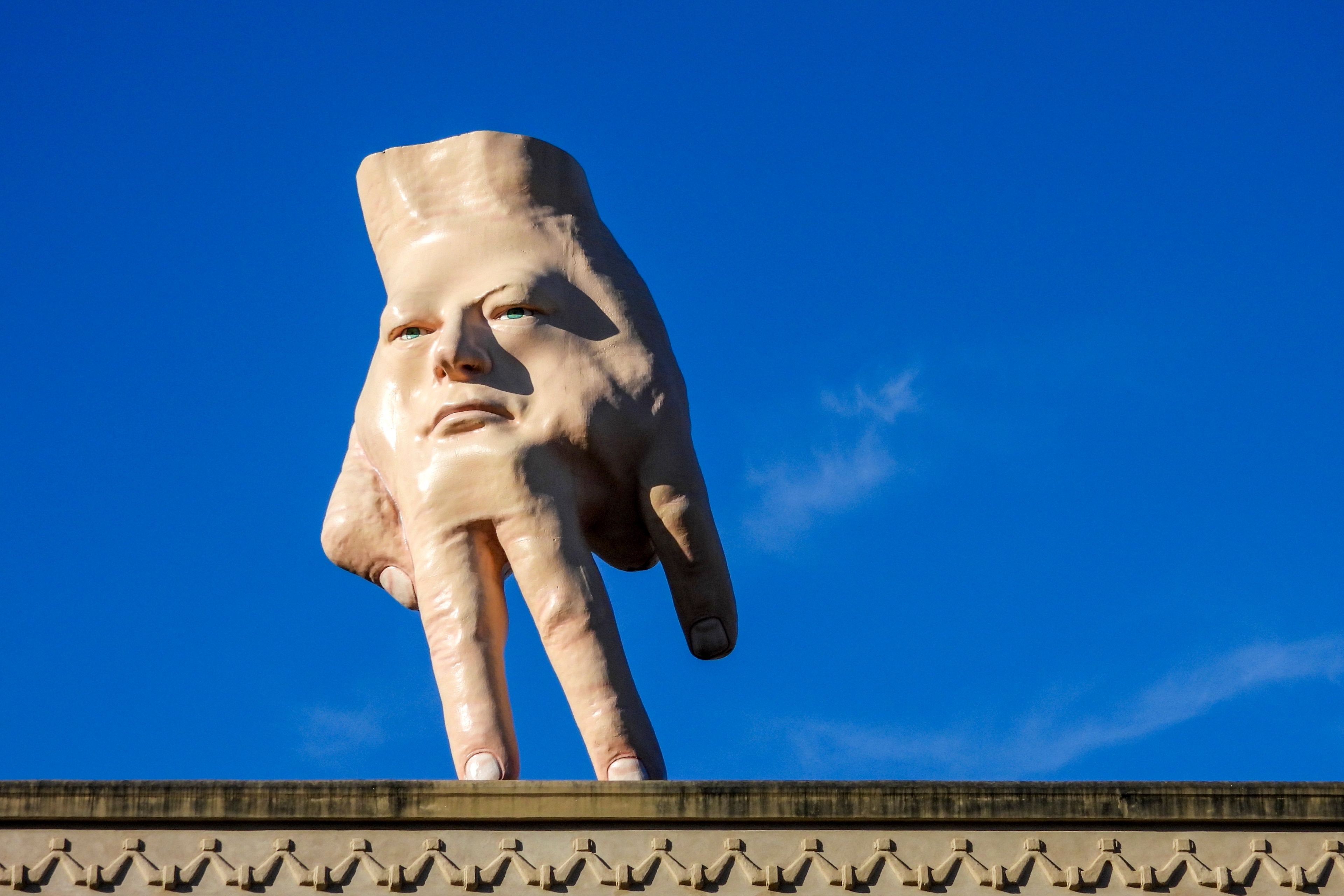 A 16-foot- ( almost 5 meters ) tall hand sculpture named Quasi stands perched on its fingertips atop the roof of an art gallery in Wellington, New Zealand, Wednesday, Oct. 30, 2024. (AP photo/Charlotte Graham-McLay)