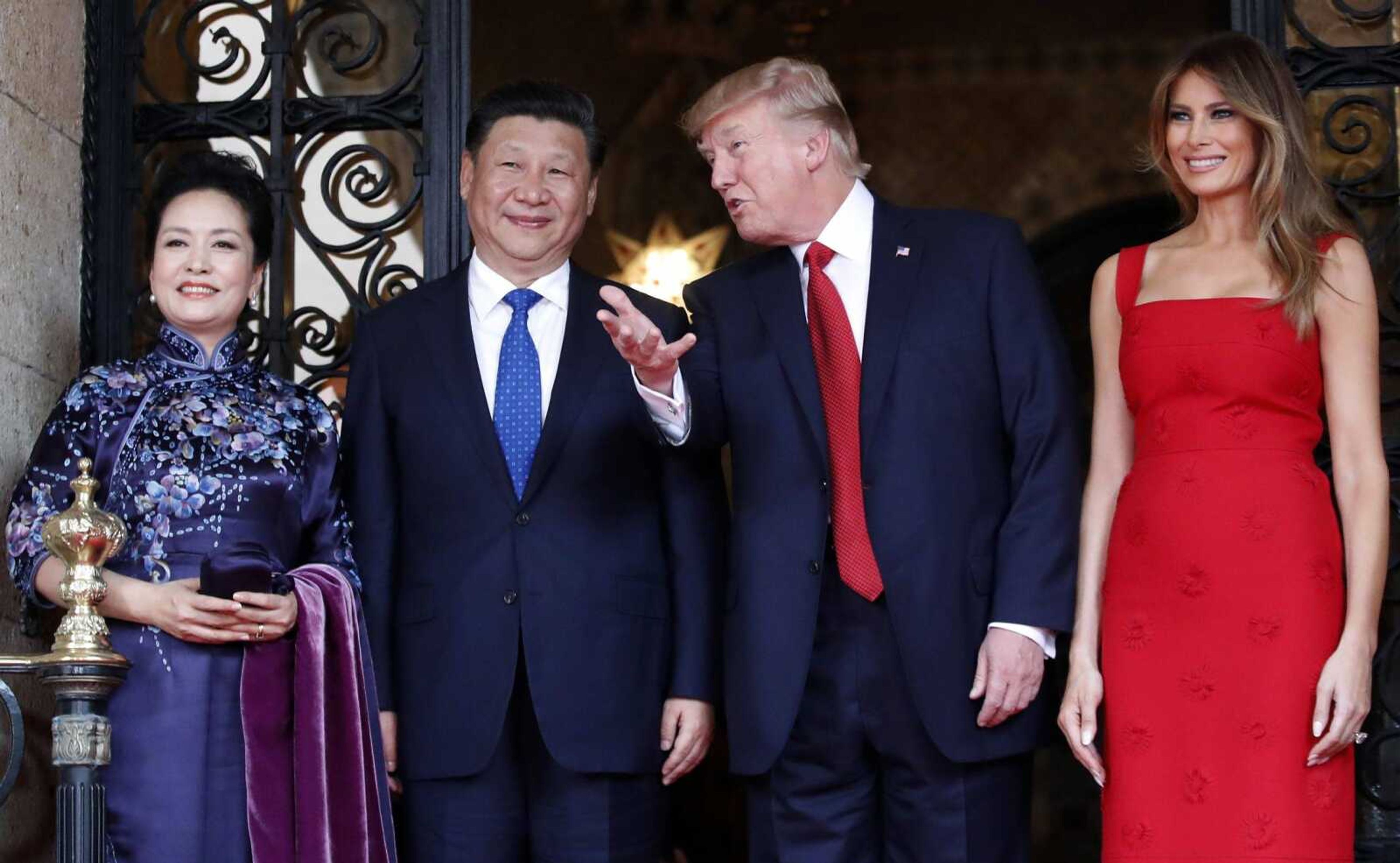 President Donald Trump talks with Chinese President Xi Jinping, with their wives, first lady Melania Trump and Chinese first lady Peng Liyuan, as they pose for photographers before dinner at Mar-a-Lago on Thursday in Palm Beach, Florida.