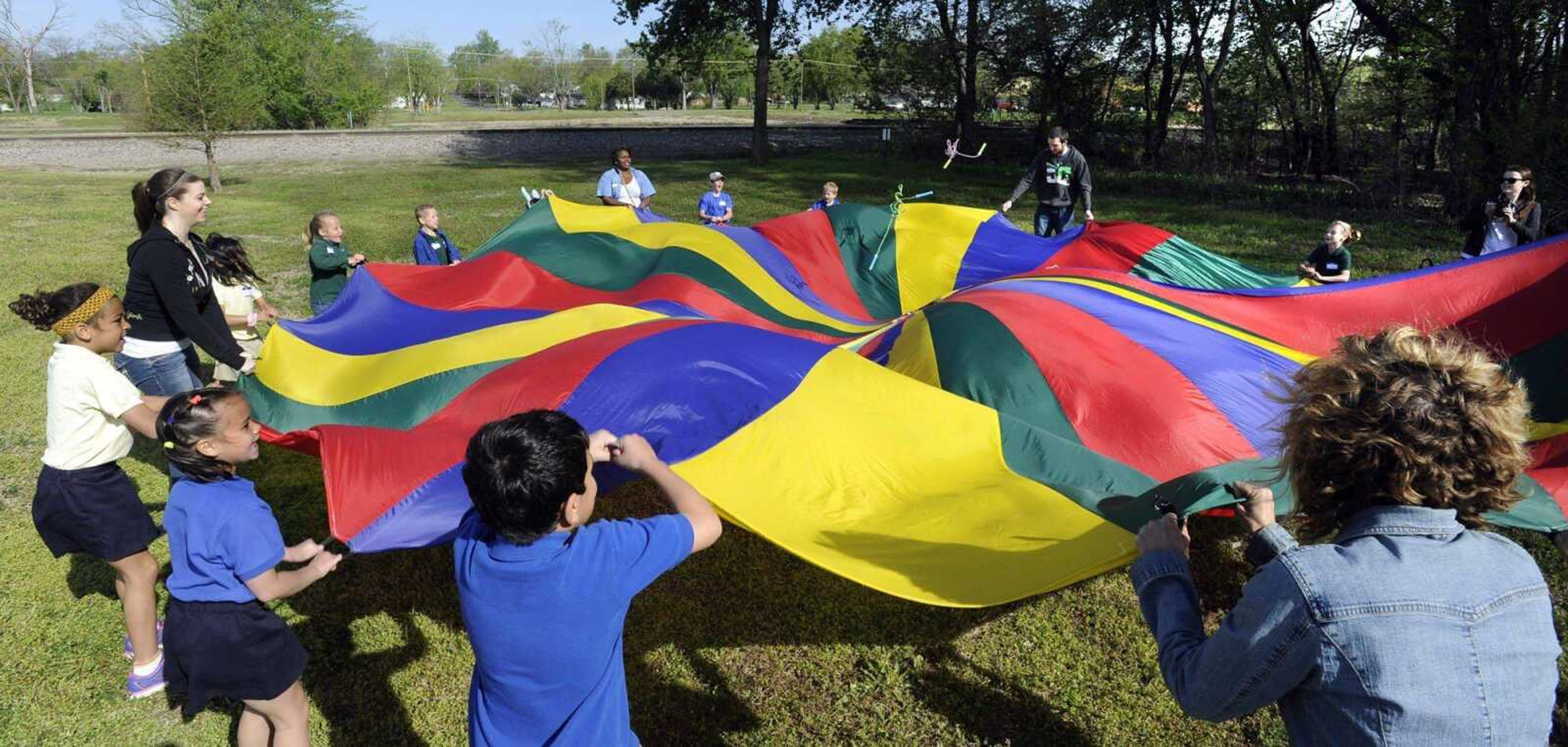 The students of Prodigy Leadership Academy have fun with a parachute Thursday after their nature walk in the woods at the Red Star Access in Cape Girardeau. (Fred Lynch)