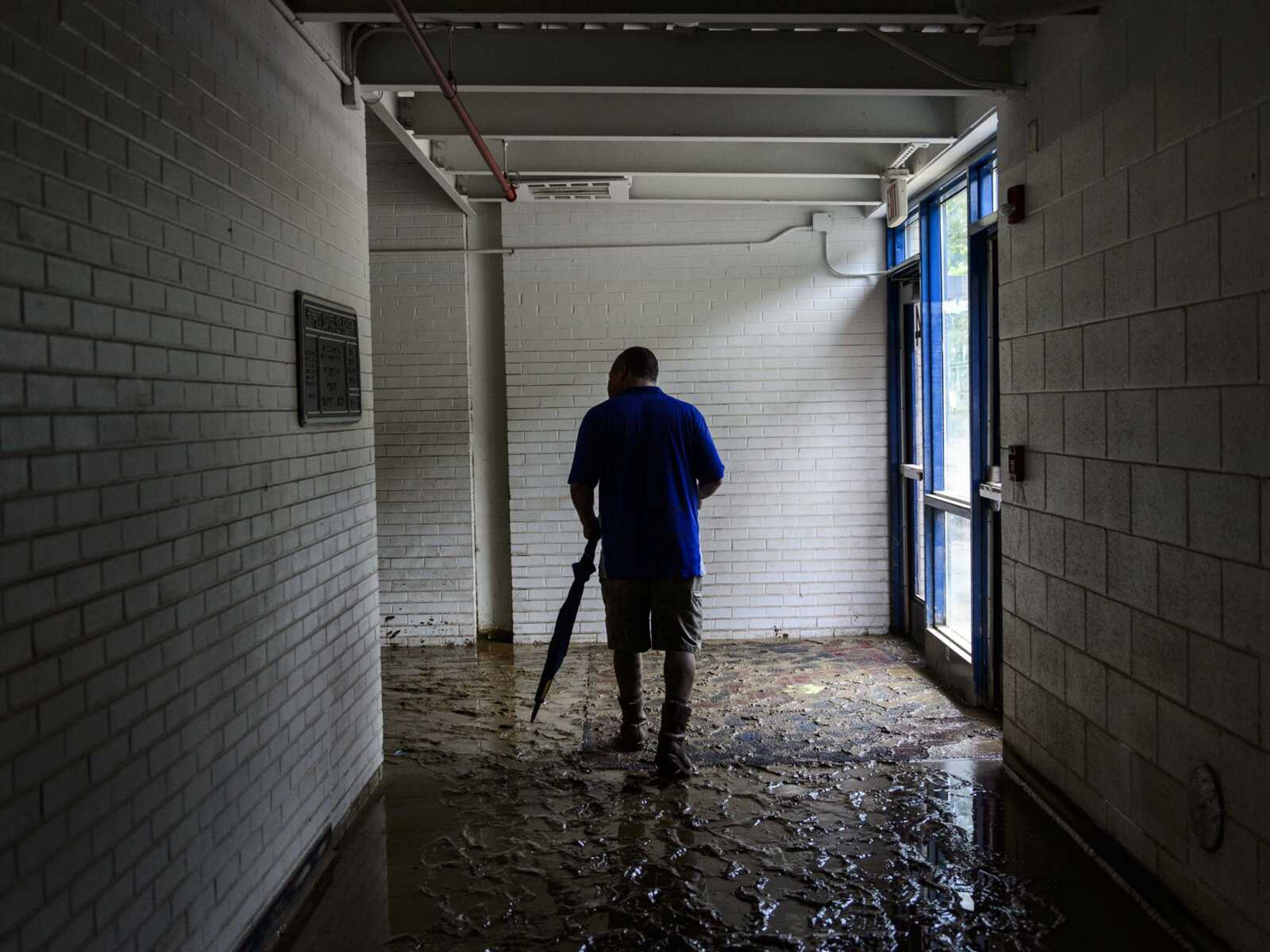 Principal Mike Kelley walks through a hallway filled with mud Monday at Herbert Hoover High School in Clendenin, West Virginia. The first floor hallways and rooms of the school are caked in 3 to 5 inches of mud, which was left by floodwater that swamped the building late last week.