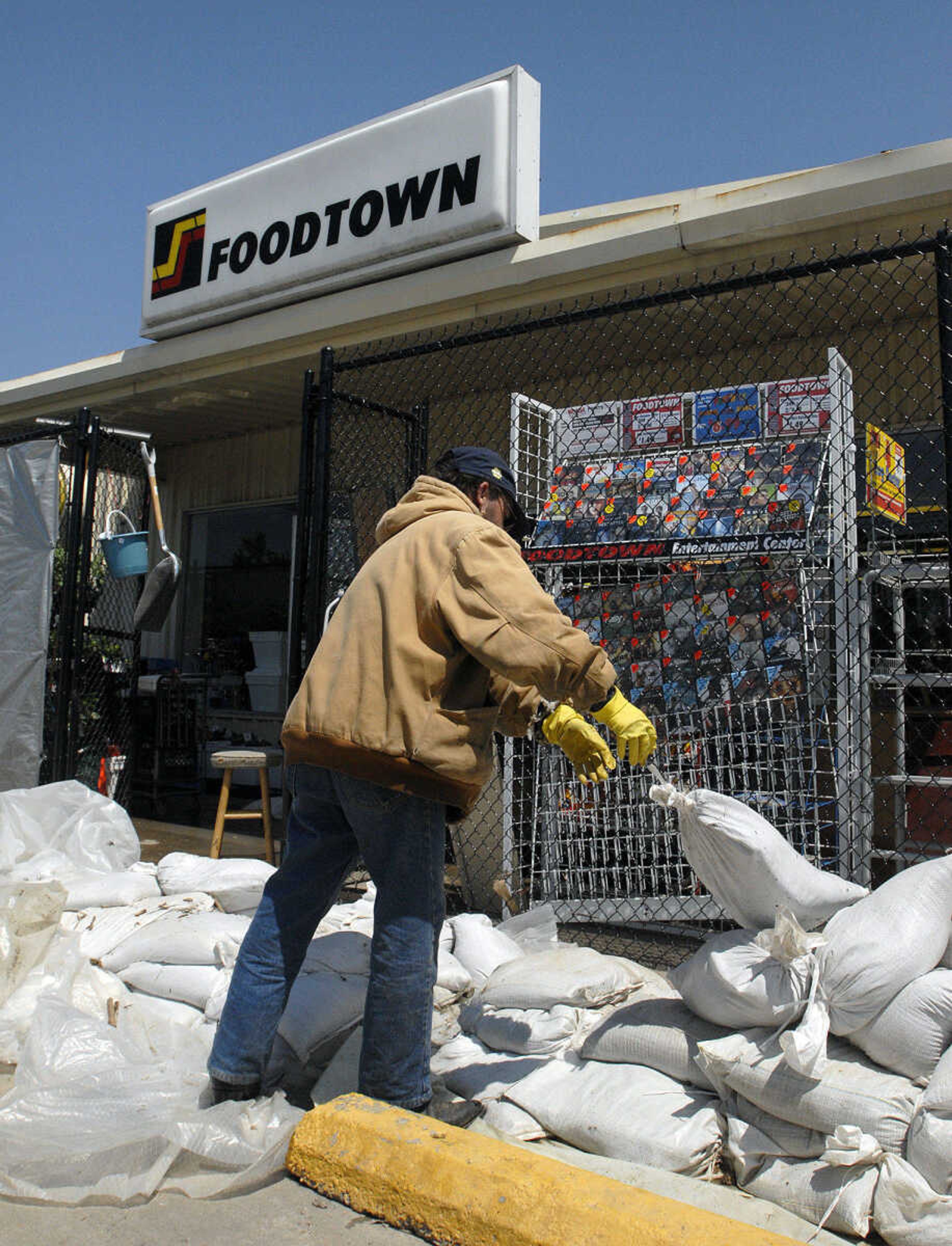 LAURA SIMON~lsimon@semissourian.com
Paul Coleson removes sandbags from the entryway of FoodTown in Olive Branch, Ill. Thursday, May 5, 2011. The store had 16 inches of water inside when floodwaters were at their highest.