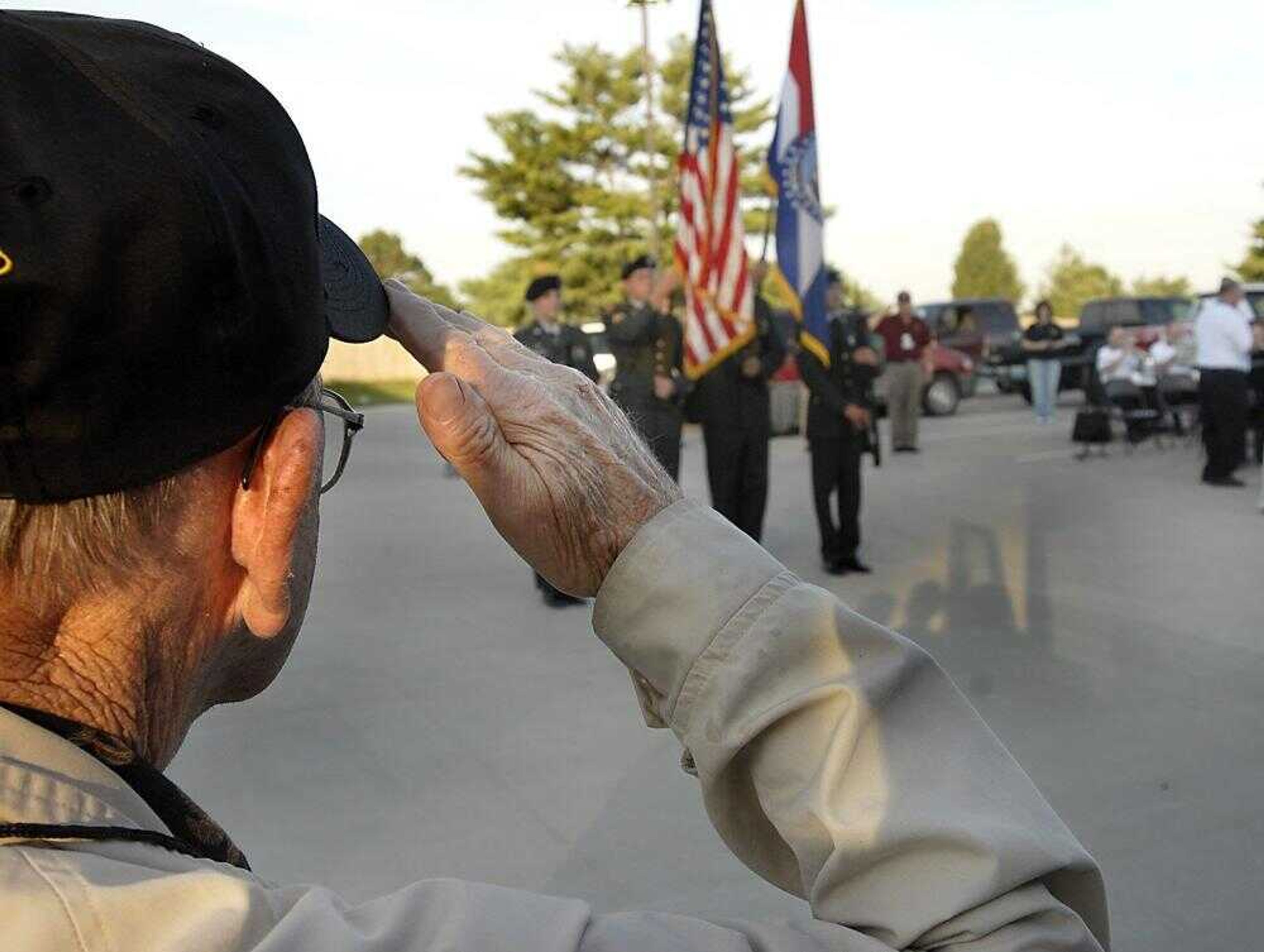 Eddie Warren saluted the color guard while the Jackson Municipal Band played "The Star-Spangled Banner" early Thursday during a send-off for 31 World War II veterans from the region who are spending the weekend in the nation's capital. (Kit Doyle)