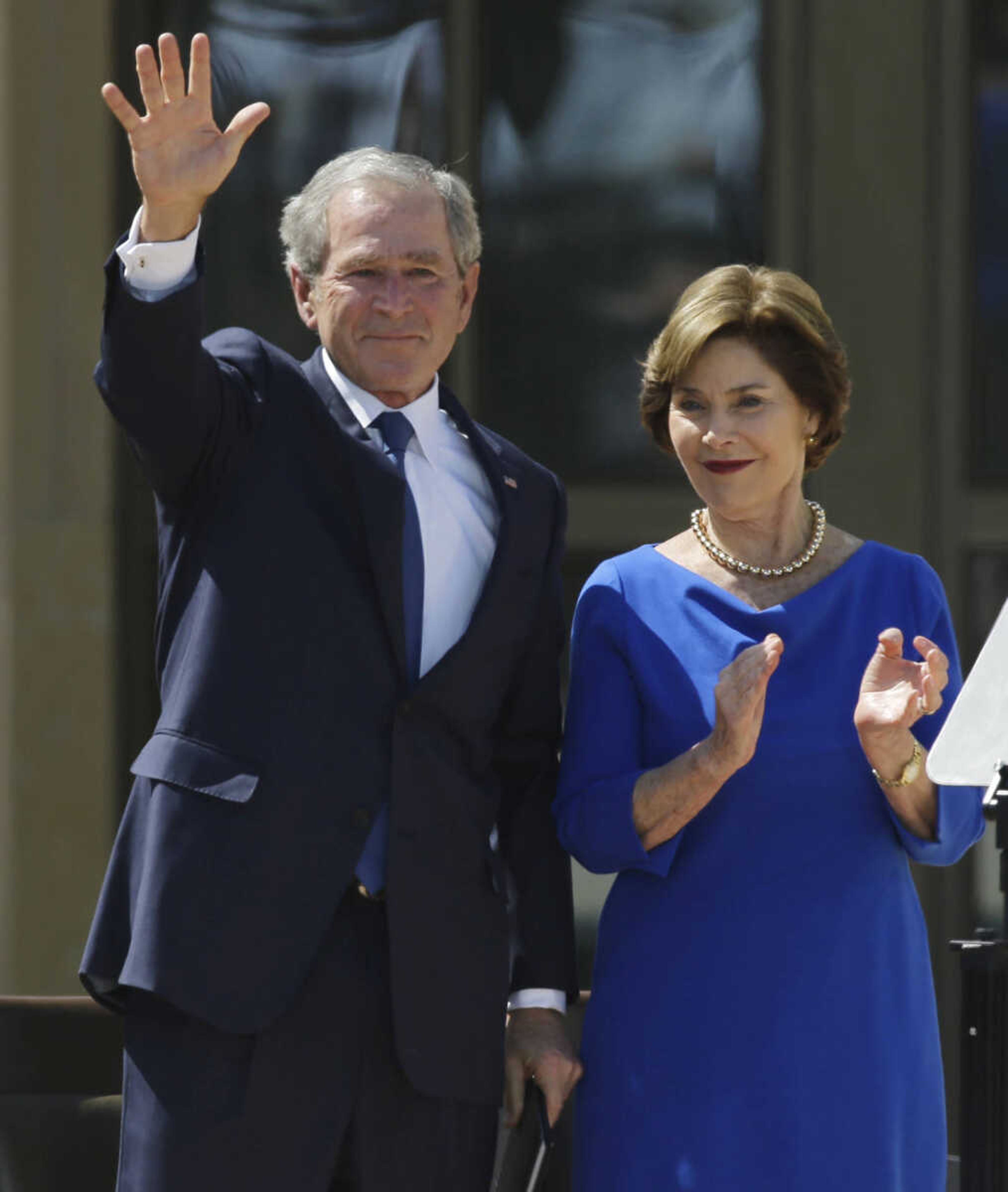 Former president George W. Bush waves with  his wife Laura speech during the dedication of the George W. Bush Presidential Center Thursday, April 25, 2013, in Dallas. (AP Photo/David J. Phillip)