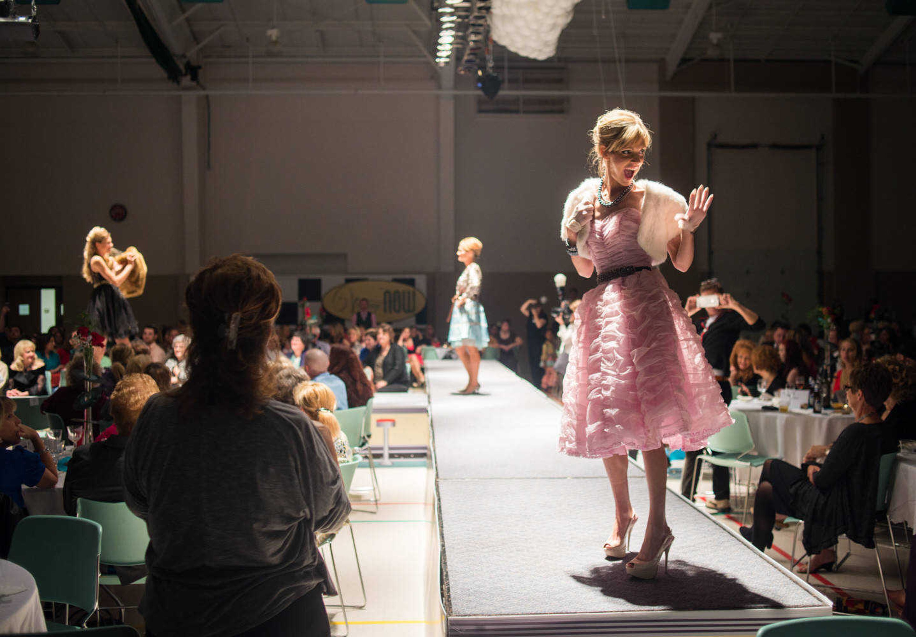 AARON EISENHAUER ~ photos@semissourian.com
Holly Brantley waves to the audience as she models a vintage gown during the VintageNOW fashion show, a fundraiser for Safe House for Women, at the Osage Centre on Friday, October 17, 2014.