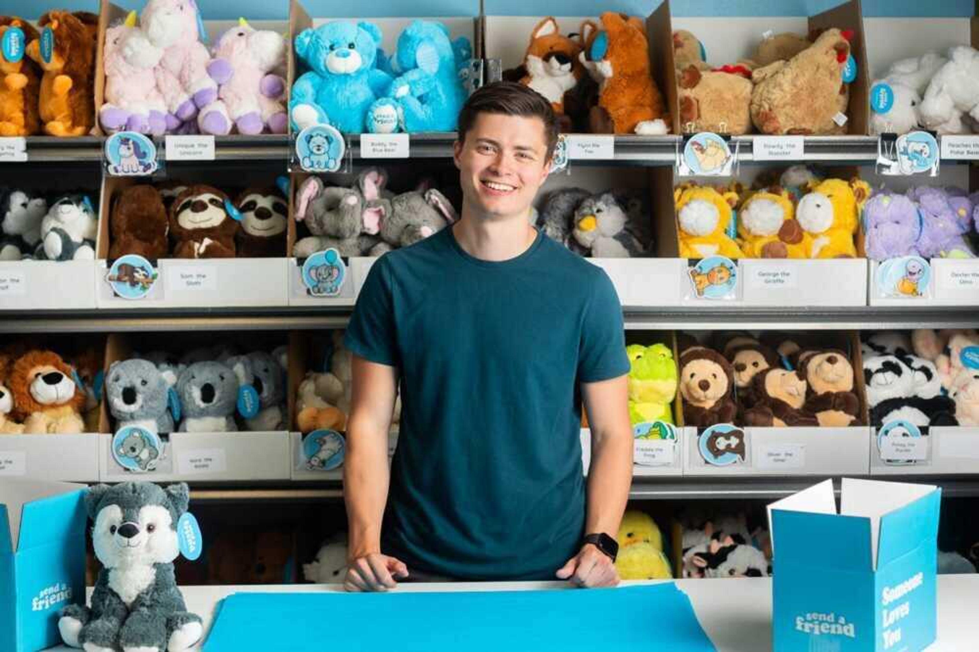 Tyler Macke, 21, poses for a photo in front of SendAFriend's stuffed animals. Macke began his business in 2018 and he is partnering with Old Town Cape to encourage youth to become entrepreneurs.