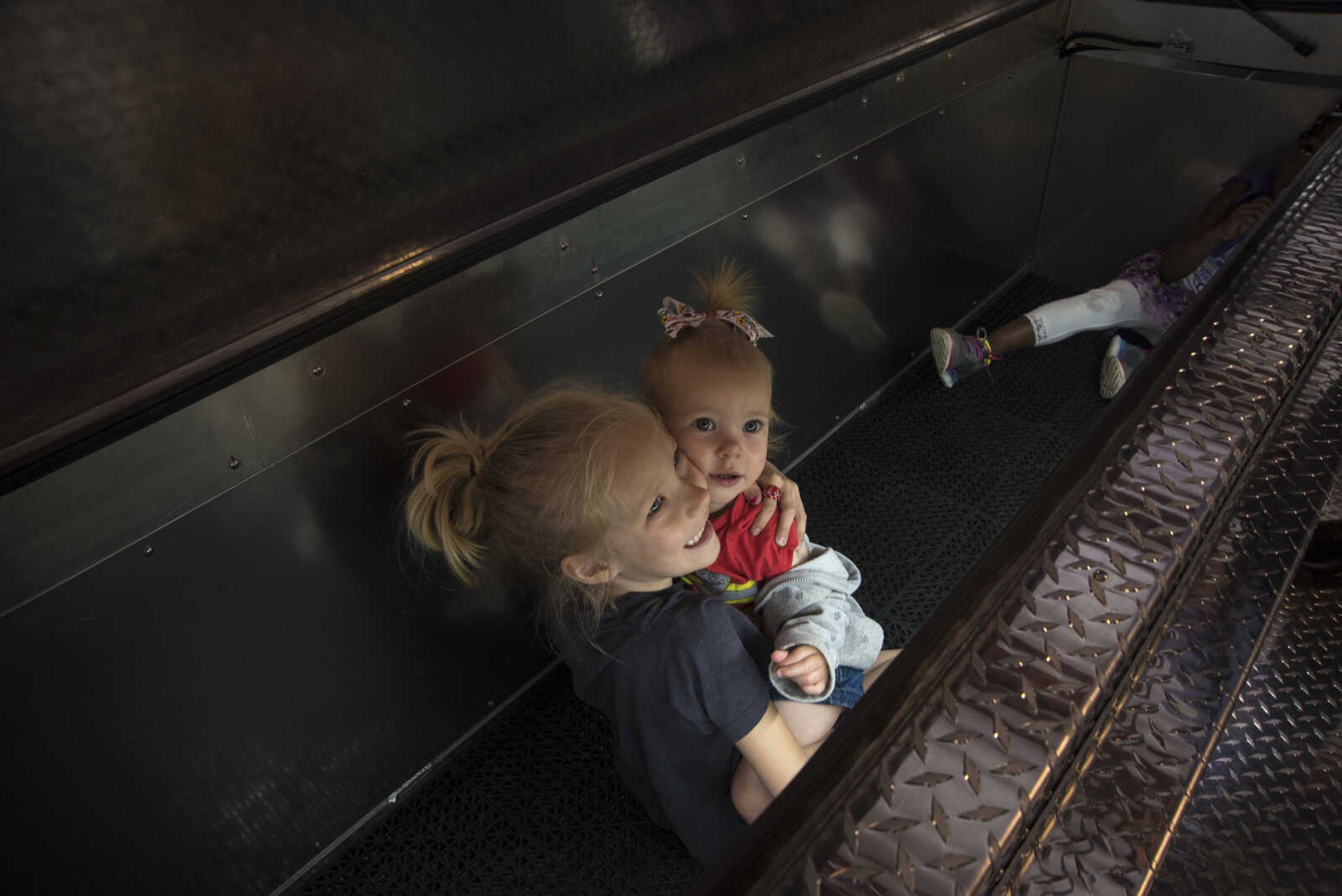 Audrey Morris, 6, and Olivia Morris, 1, sit inside a compartment on a fire truck during the showing of the six Cape Girardeau fire trucks purchased at fire station number two Saturday, April 15, 2017 in Cape Girardeau. The National Fire Protection Association recommends fire departments to rotate their fleet every 10 years costing approximately $3.8 million dollars.