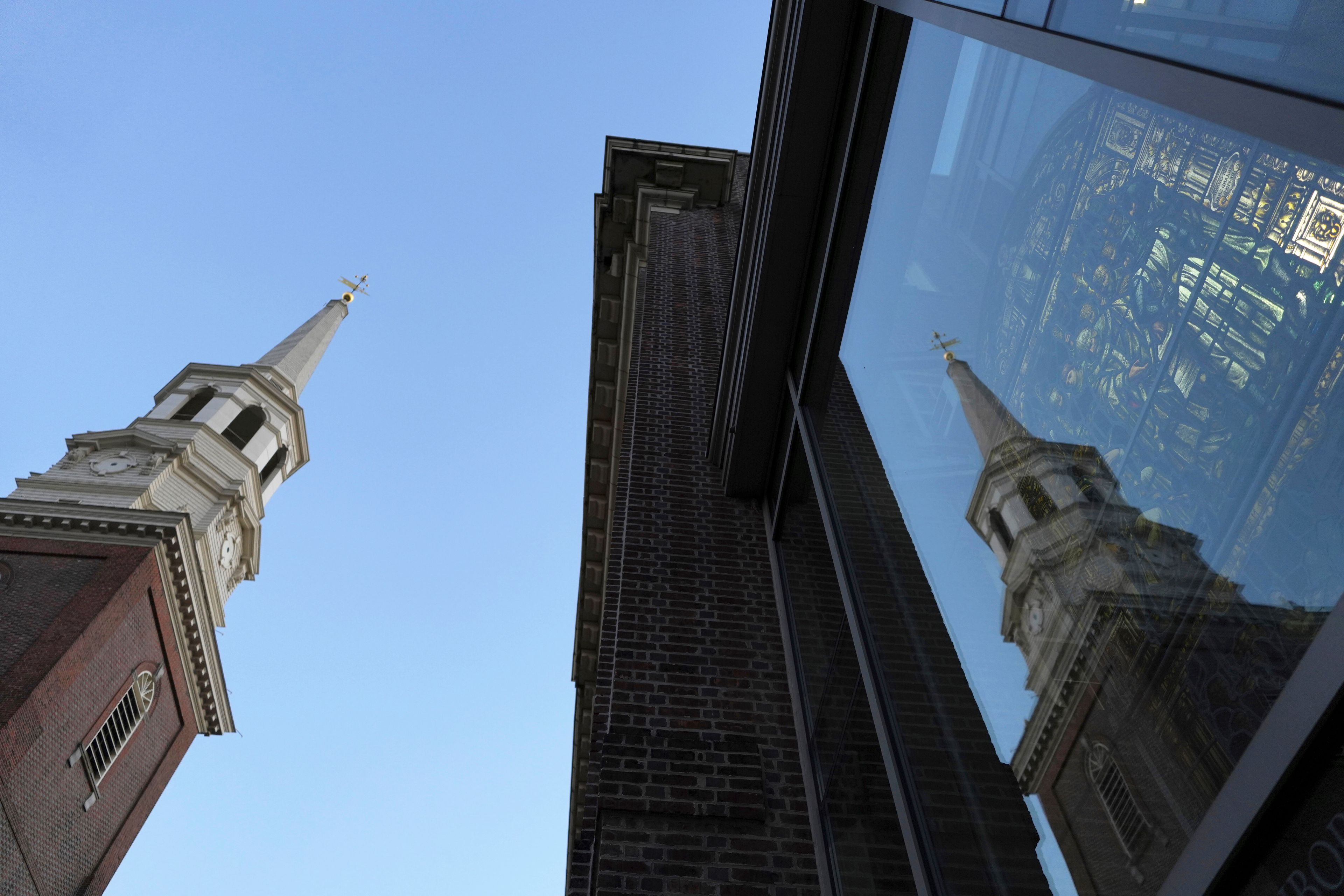 The Christ Church steeple is reflected on “Liberty Window,” a stained-glass window depicting the First Prayer of Congress on display located at the church Neighborhood House in Philadelphia on Sunday, Oct. 6, 2024. (AP Photo/Luis Andres Henao)