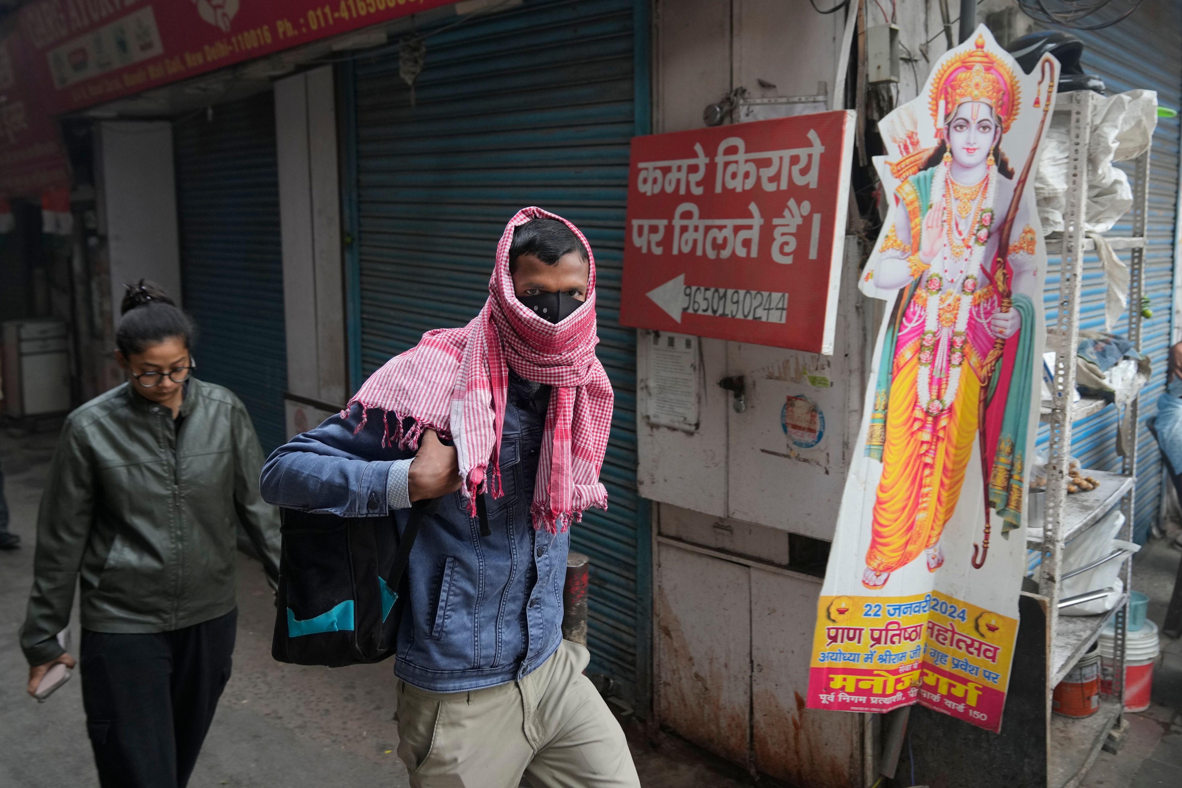 A office goer walks wearing a face mask amidst a thick layer of smog as air pollution shoots up in New Delhi, India, Monday, Nov. 18, 2024. (AP Photo/Manish Swarup)