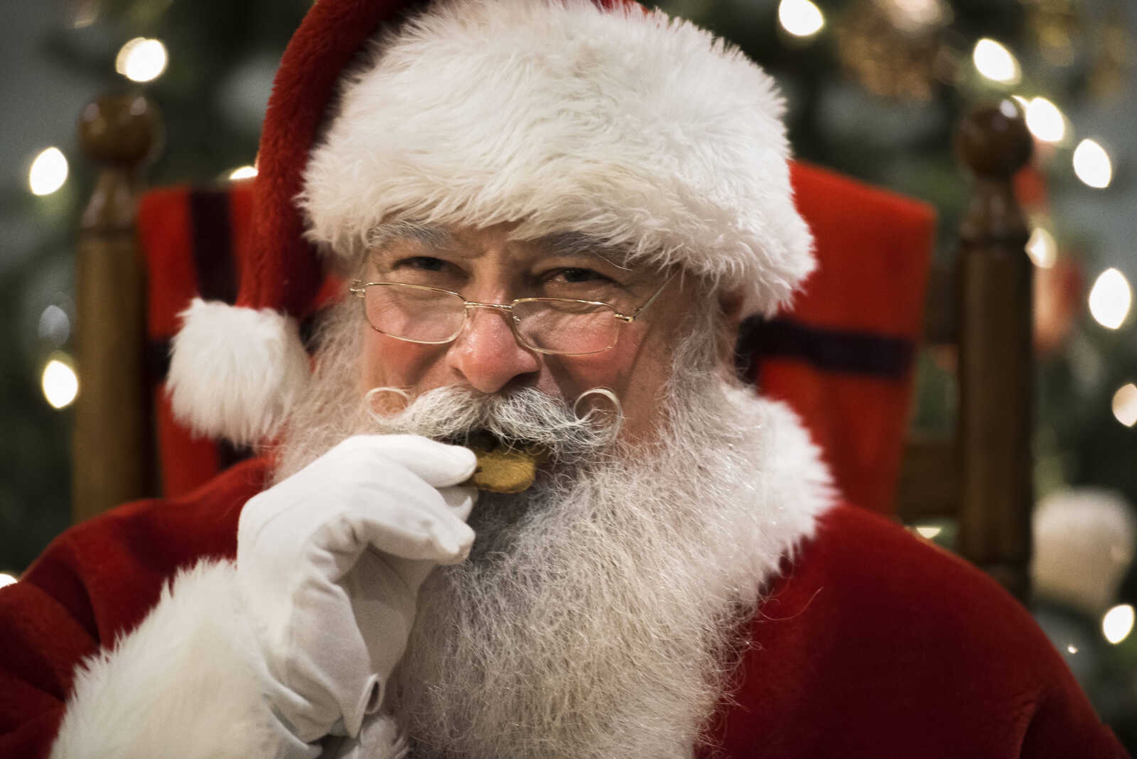 Santa Claus, portrayed by Donnie LeGrand, bites into a Christmas cookie during a house call on Monday, Nov. 18, 2019, in Scott City, Missouri.&nbsp;