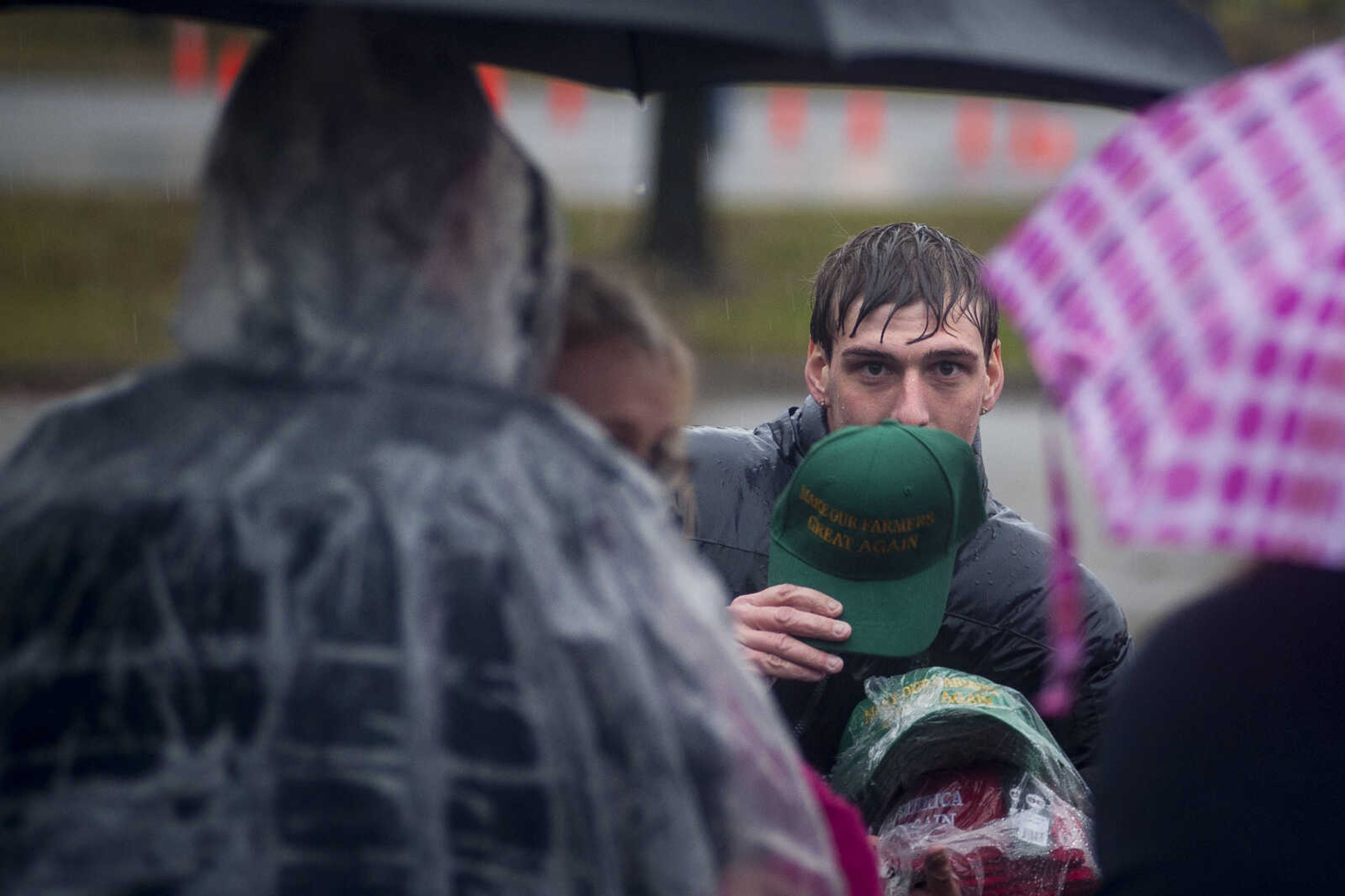 A vendor tries to sell a "Make Our Farmers Great Again" hat to attendees waiting in a long line while standing outside in the rain Monday, Nov. 5, 2018, in Cape Girardeau.