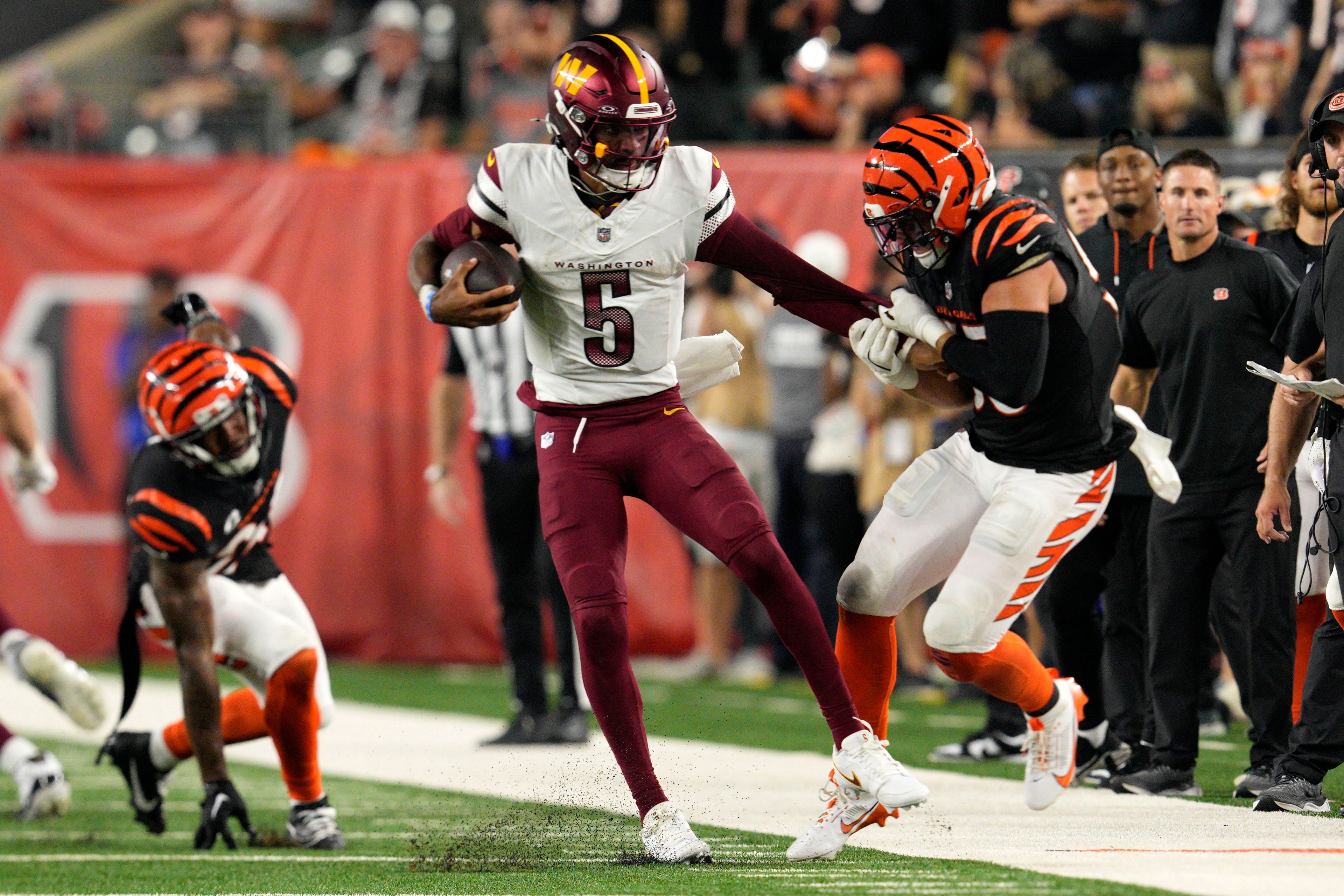 Washington Commanders quarterback Jayden Daniels (5) is tackled by Cincinnati Bengals linebacker Logan Wilson, right, during the second half of an NFL football game, Monday, Sept. 23, 2024, in Cincinnati. (AP Photo/Jeff Dean)