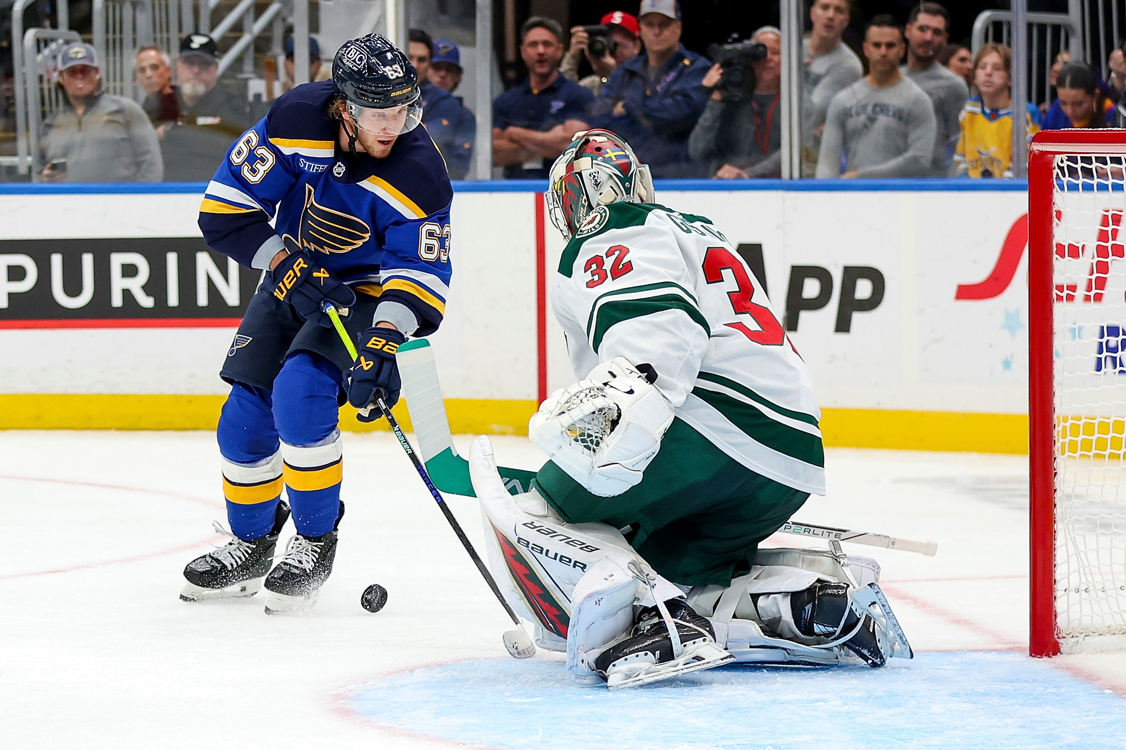 Minnesota Wild goaltender Filip Gustavsson (32) defends against St. Louis Blues' Jake Neighbours (63) during the second period of an NHL hockey game Tuesday, October 15, 2024, in St. Louis. (AP Photo/Scott Kane)