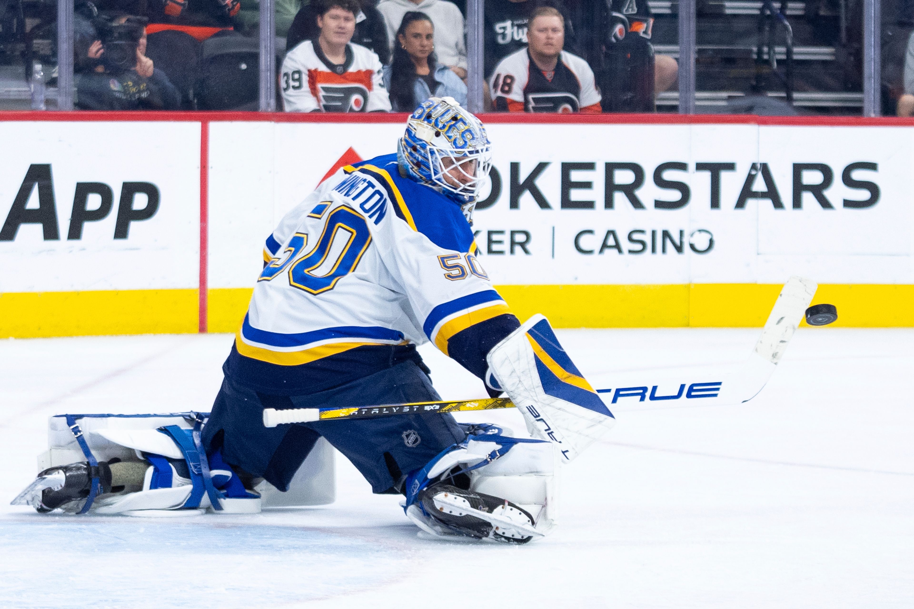 St Louis Blues' Jordan Binnington knocks away the puck during the second period of an NHL hockey game against the Philadelphia Flyers, Thursday, Oct. 31, 2024, in Philadelphia. (AP Photo/Chris Szagola)