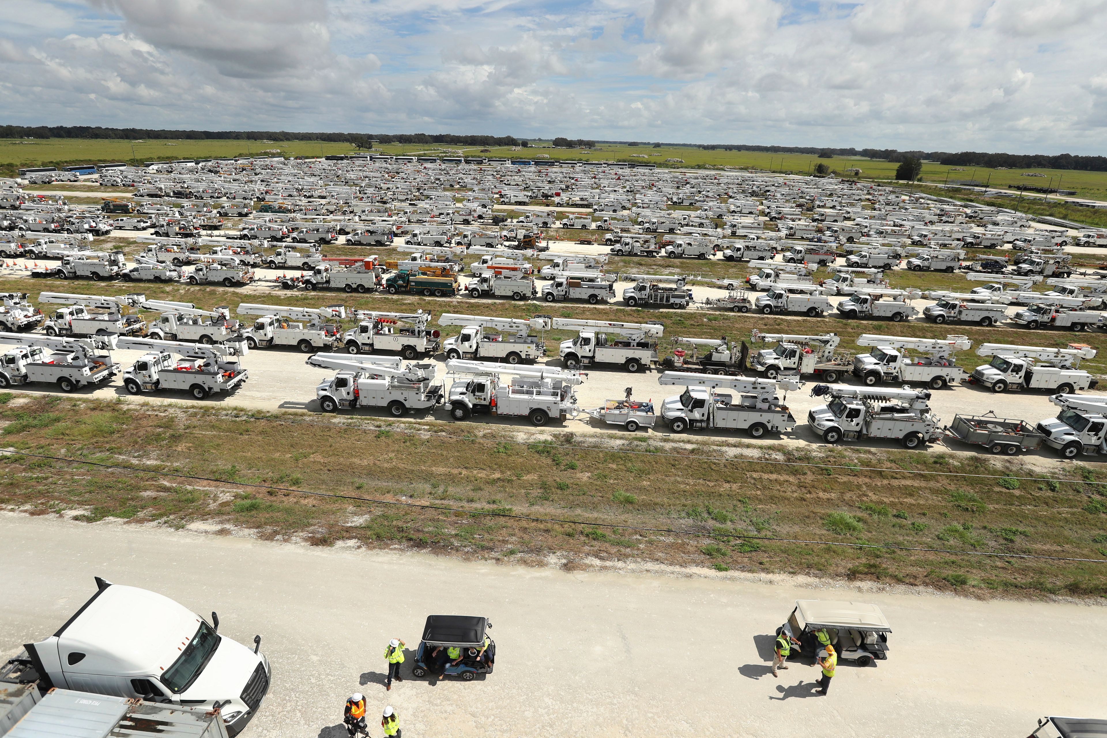 Linemen gather in front of hundreds of utility trucks staged, Tuesday, Oct. 8, 2024. at The Villages, Fla. in preparation for Hurricane Milton.(Stephen M. Dowell/Orlando Sentinel via AP)