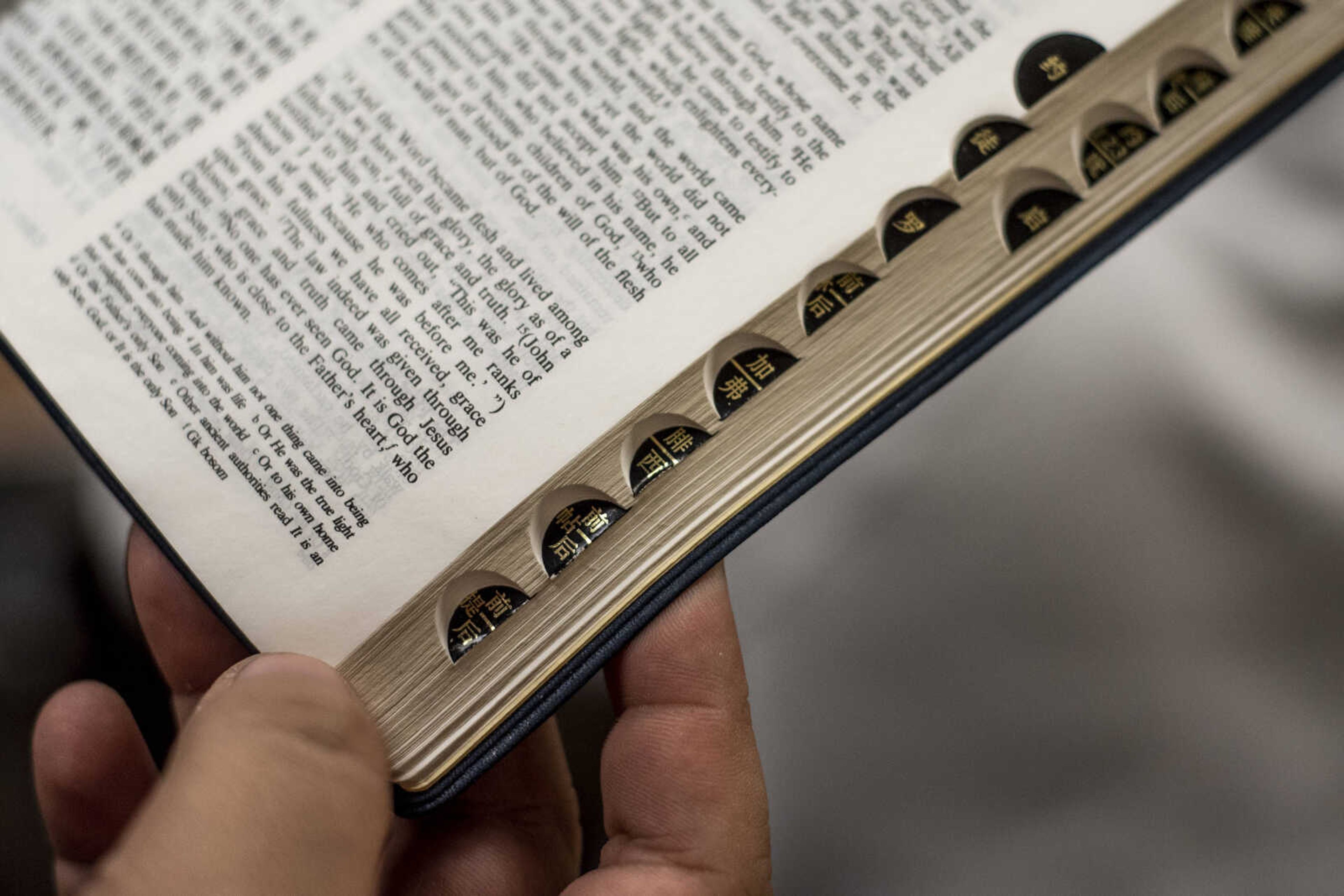 Wuwei (Peter) Lan holds his Chinese English Bible, showing the tabs labeling each book in Mandarin Friday, March 8, 2019, at the Southeast Missouri State University Baptist Student Center in Cape Girardeau.