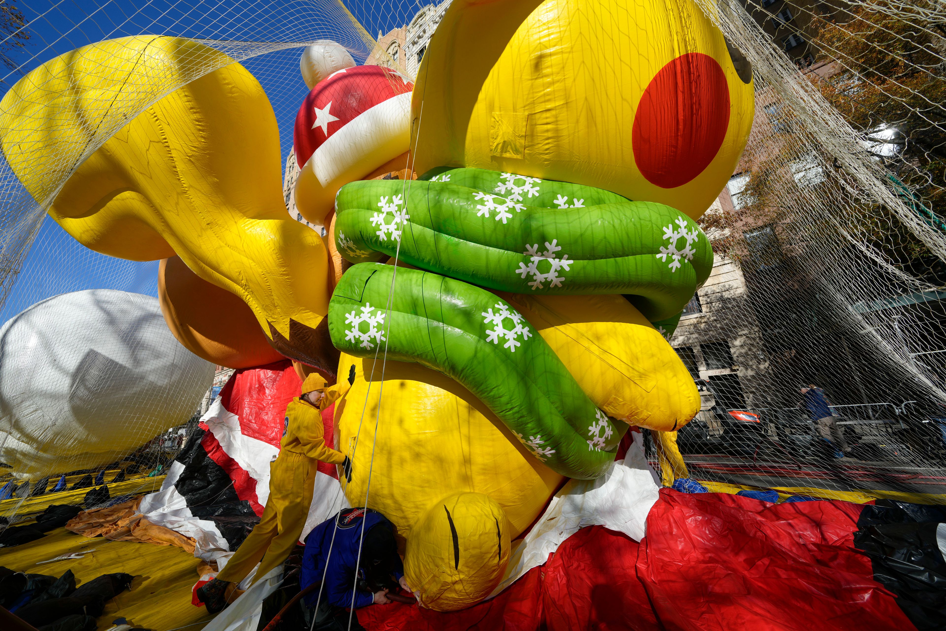 People help to inflate a Pikachu float for the Macy's Thanksgiving Day Parade in New York, Wednesday, Nov. 27, 2024. (AP Photo/Seth Wenig)